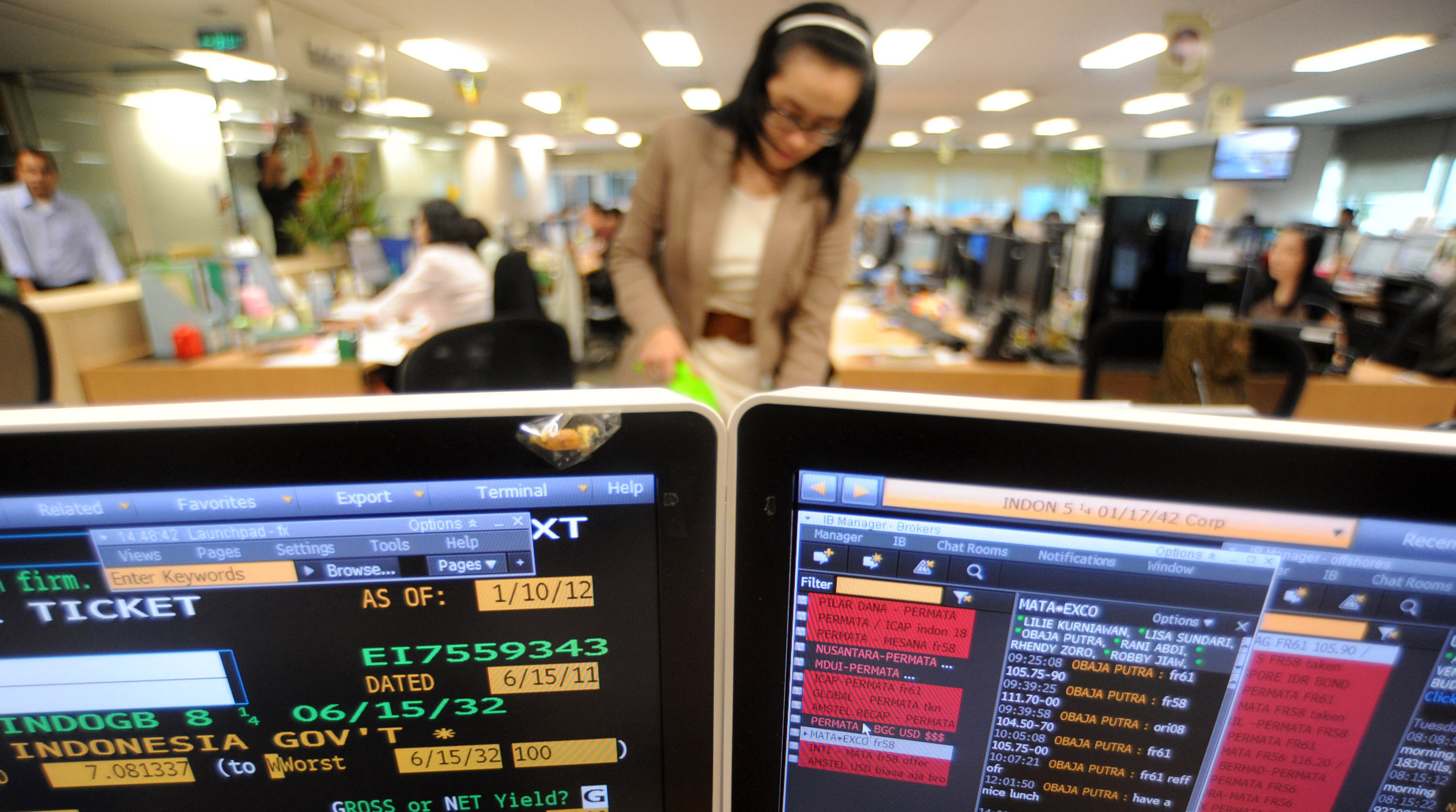 Ilustrasi karyawan memantau pergerakan pasar uang dan obligasi.