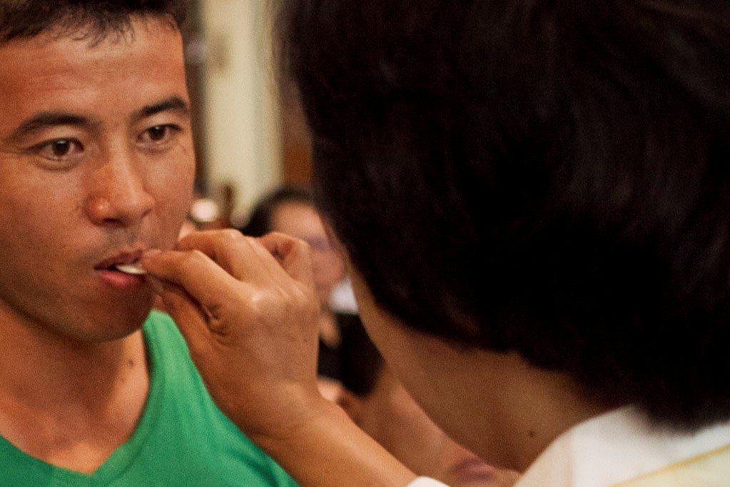 Ilustrasi pemberian komuni yang disuapkan. 