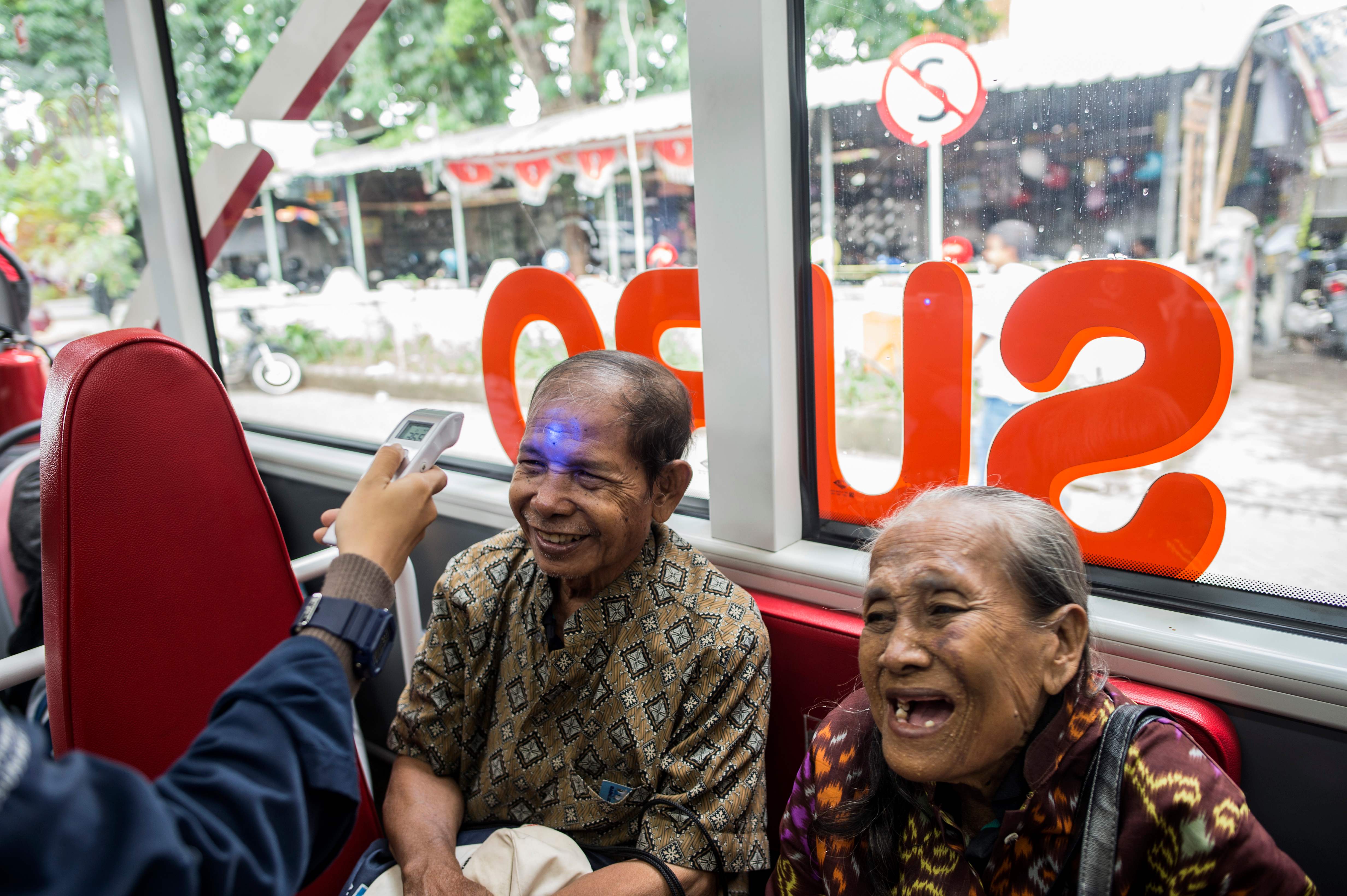 Petugas memeriksa suhu tubuh penumpang bus di Surabaya untuk pencegahan virus korona