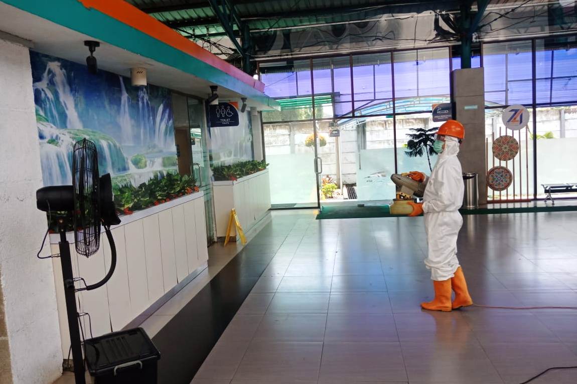 Petugas KAI membersihkan stasiun dan gerbong kereta api dengan cairan disinfektan, Kamis (19/3).