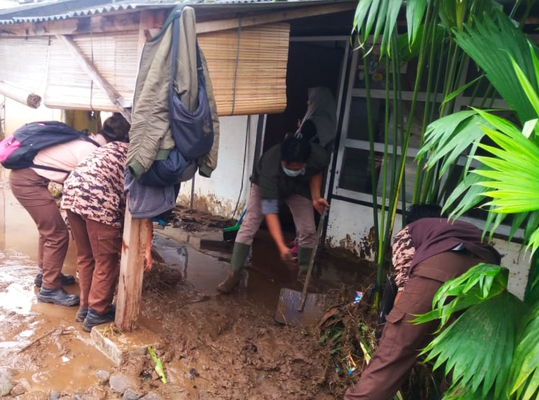 Warga Desa Gununghalu, Kecamatan Gununghalu, Kabupaten Bandung Barat membersihkan lumpur banjir di depan rumah, Jumat (27/3/2020).