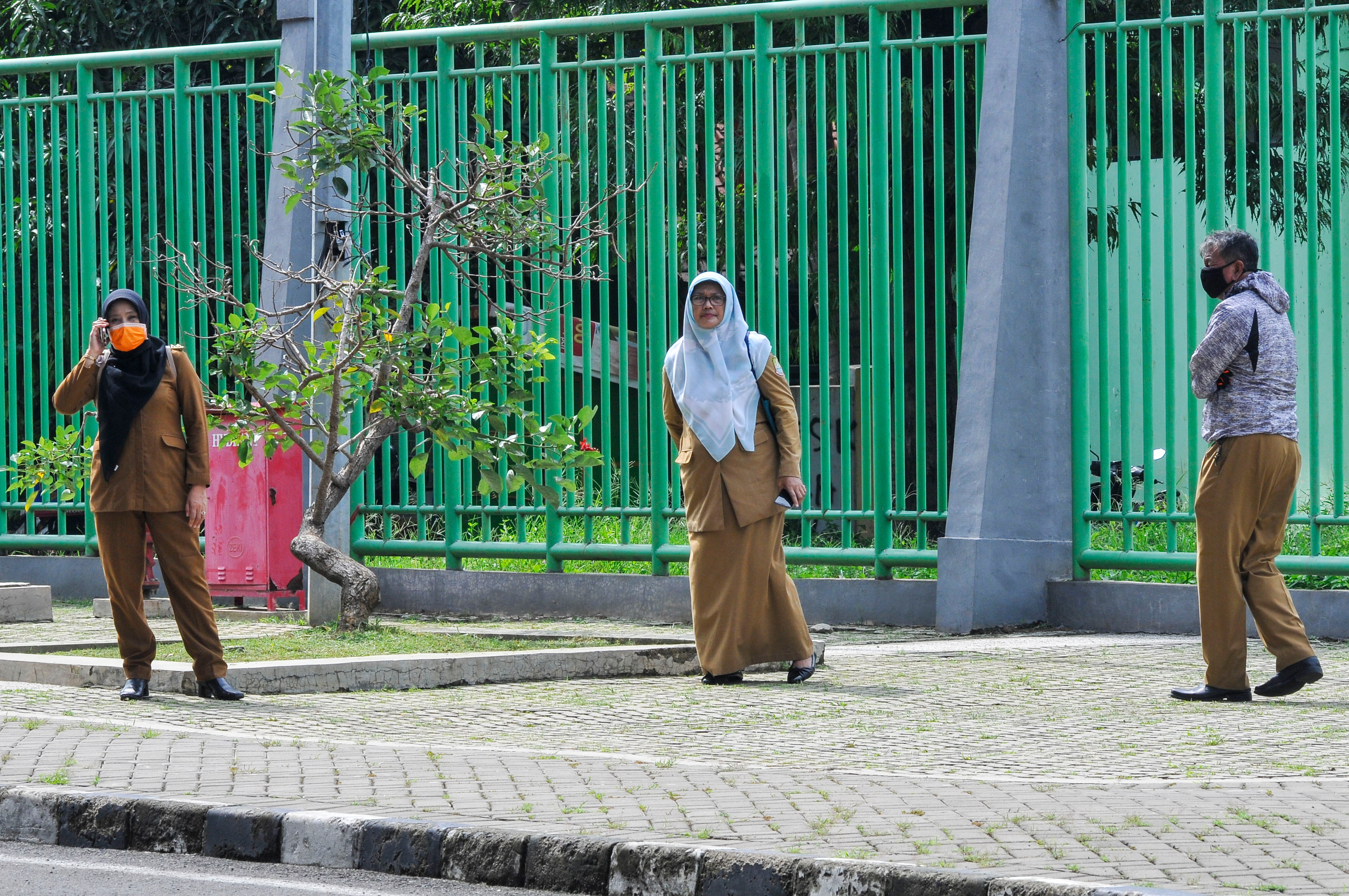 Sejumlah pekerja menerapkan kebijakan pengaturan jarak (physical distancing) saat menunggu rapat kordinasi penanganan virus COVID-19.