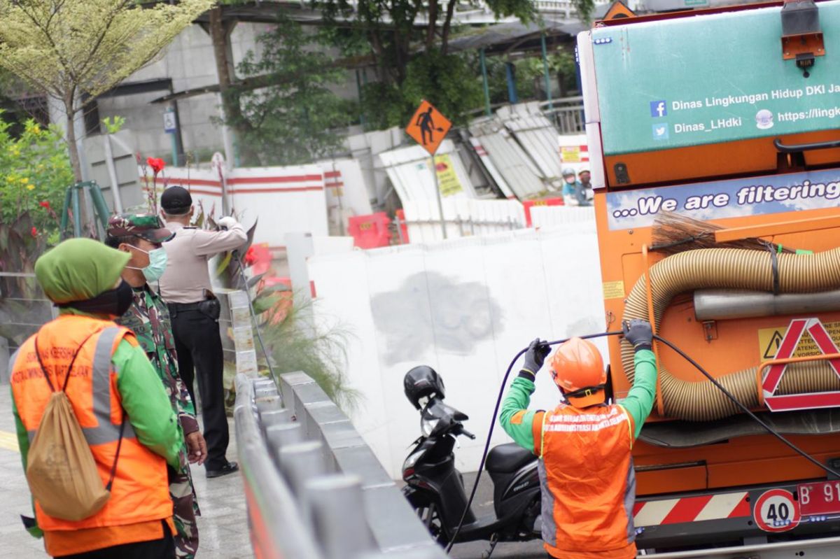 Petugas melakukan penyemprotan disinfektan pada fasilitas umum di Jakarta