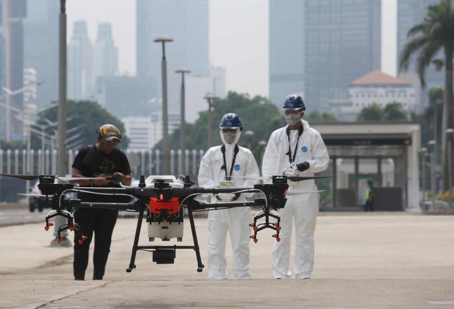 Petugas menyiapkan drone yang digunakan untuk meyemrotkan disinfektan di kawasan Jalan Jenderal Sudirman, Jakarta.