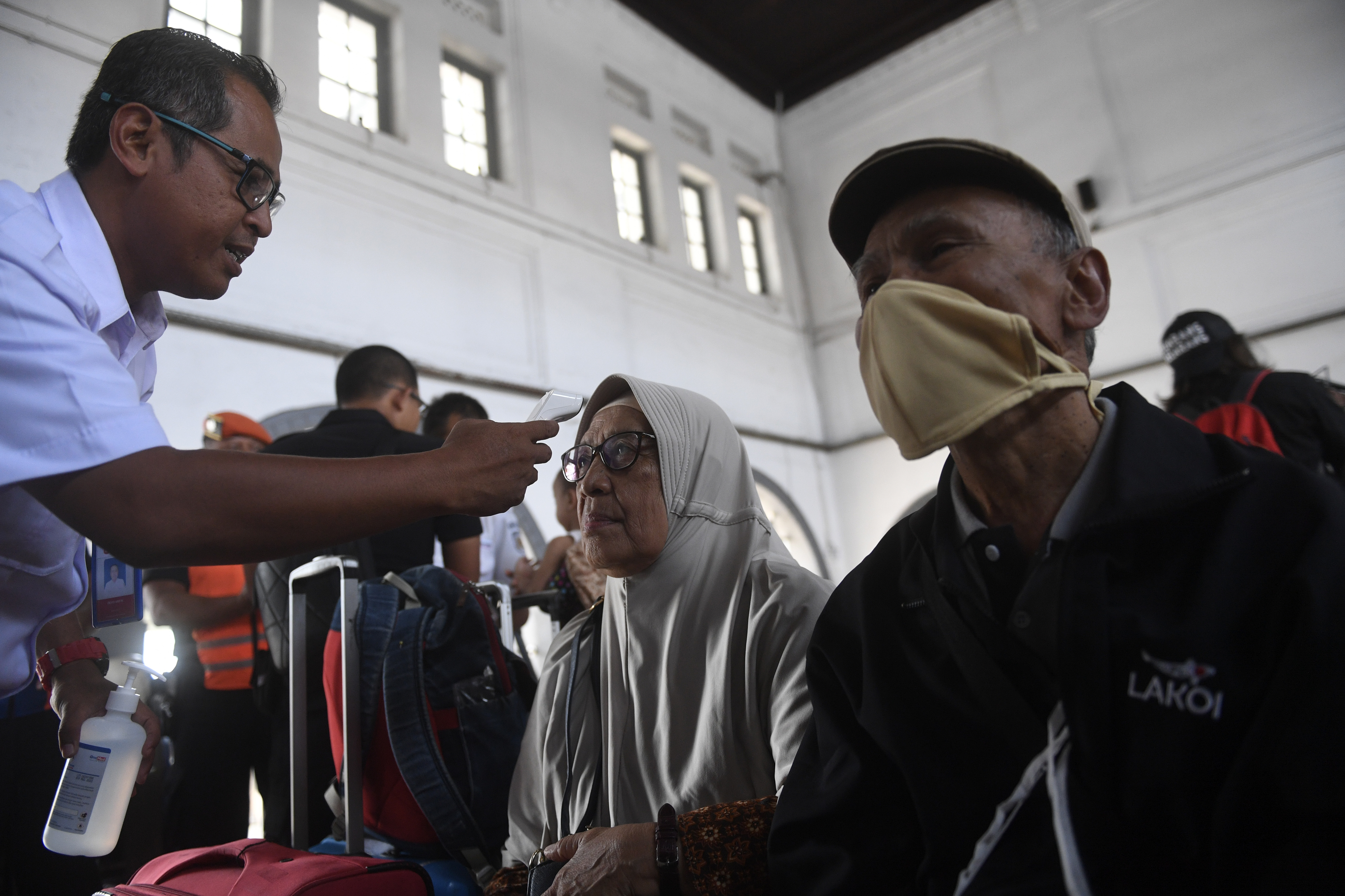 Penumpang kereta api mengenakan masker. Kapolres Lamongan mengingatkan siapa saja yang menimbun masker akan ditindak. 