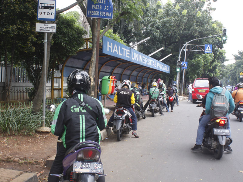 Pengemudi ojek online menunggu penumpang. 