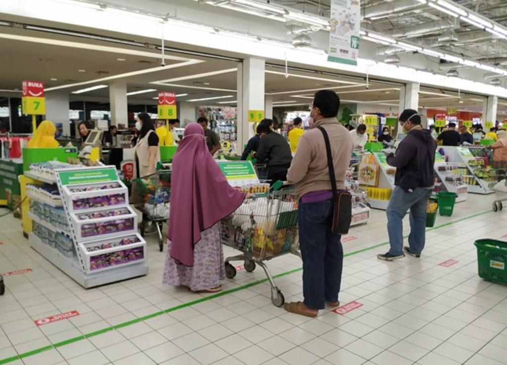 Para pembeli harus menjaga jarak dengan pembali lain saat akan membayar di kasir.