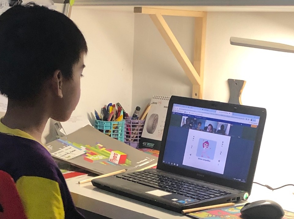 Seorang anak sedang belajar bahasa Inggris secara online di rumahnya.