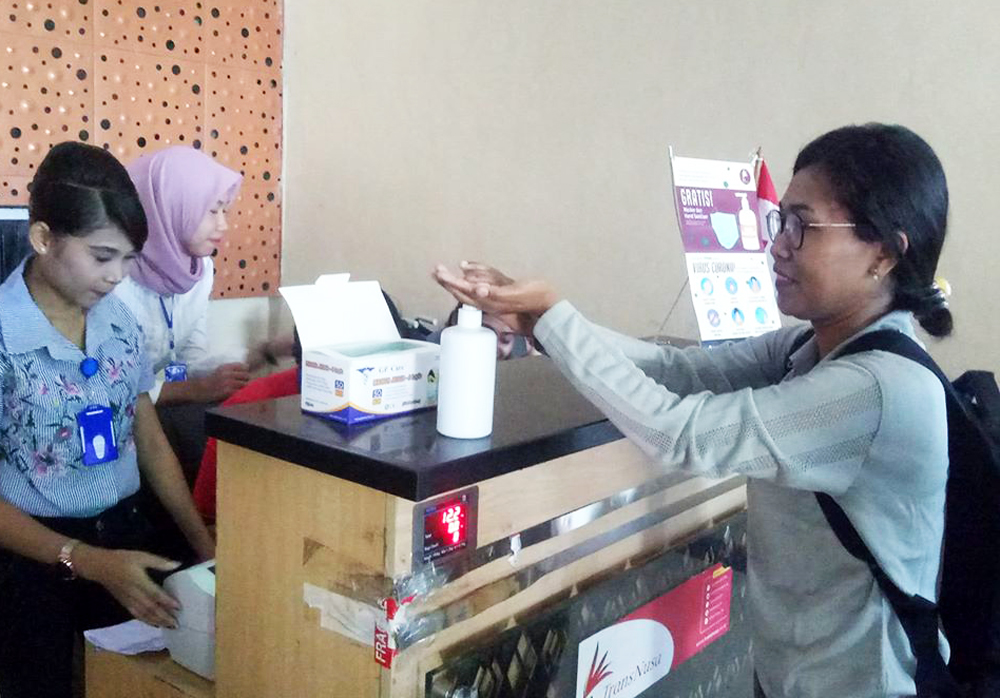 Seorang penumpang mencuci tangan dengan hand sanitizer saat  check in di Bandara Komodo di Kabupaten Manggarai Barat, NTT, Selasa  (17/3). 