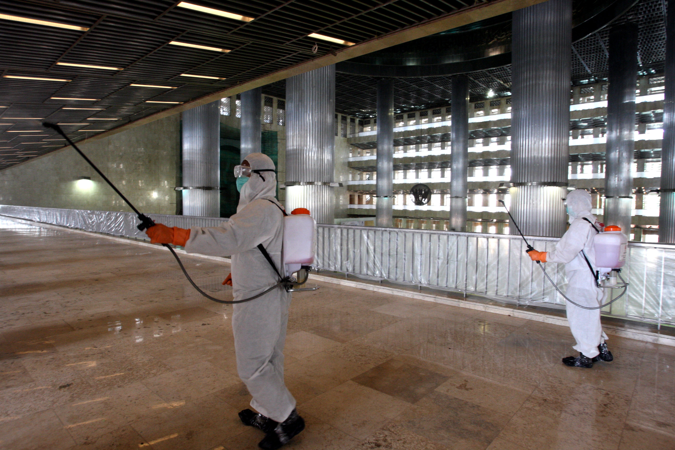 Ilustrasi--Petugas Palang Merah Indonesia (PMI) menyemprotkan disinfektan di area masjid Istiqlal, Jakarta.