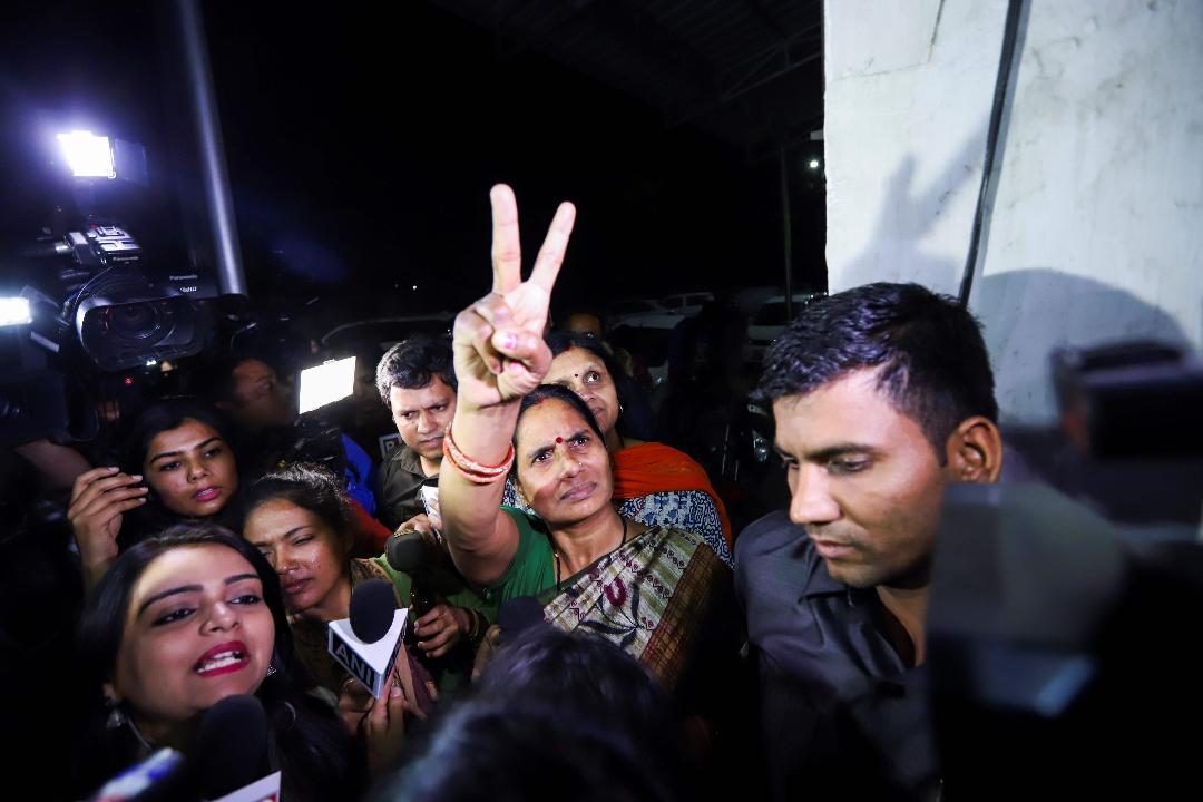 Asha Devi (tengah), ibu dari korban pemerkosaan datang ke lokasi eksekusi hukum gantung para pelaku di New Delhi, India, Jumat (20/3).