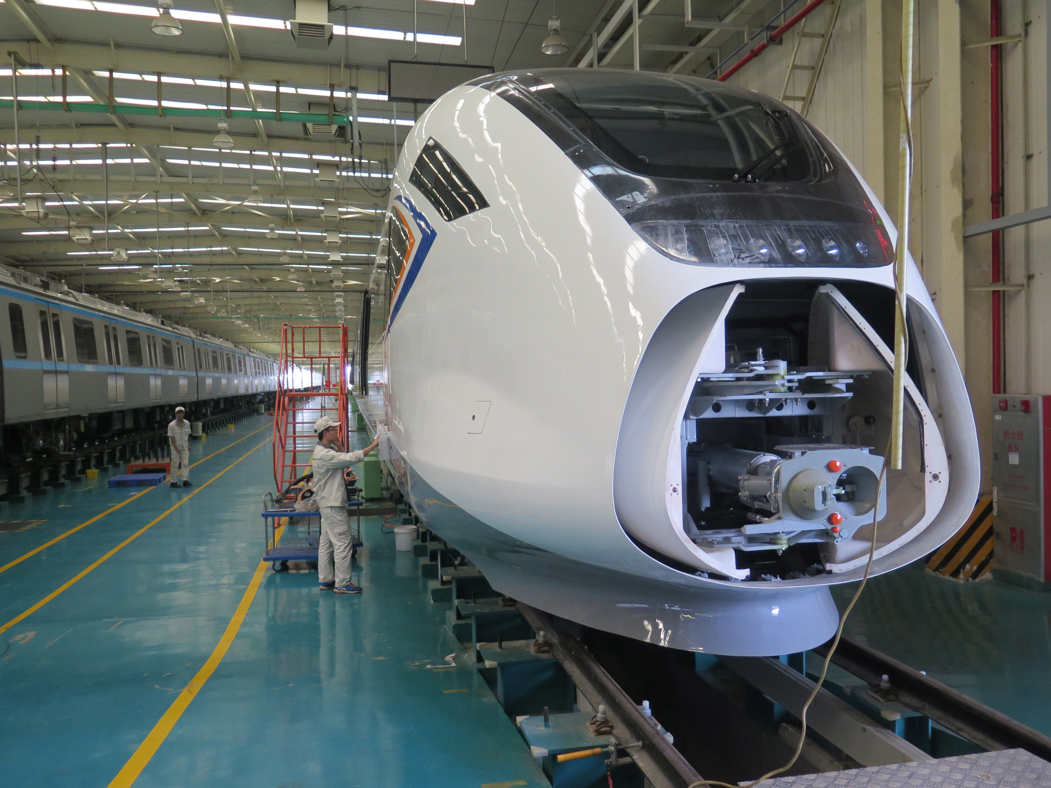 Pekerja menyelesaikan tahap akhir produksi rangkaian kereta cepat di pabrik kereta CRRC Guangdong, Jiangmen, Tiongkok. 