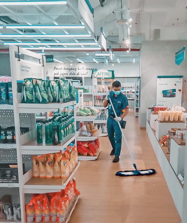 Petugas membersihkan gudang tempat barang.