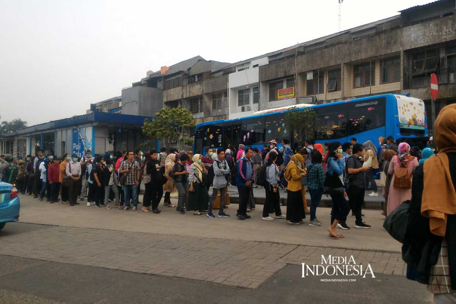 Antrean penumpang bus TransJakarta di halte Puri beta, Ciledug, Senin (16/3/2020)