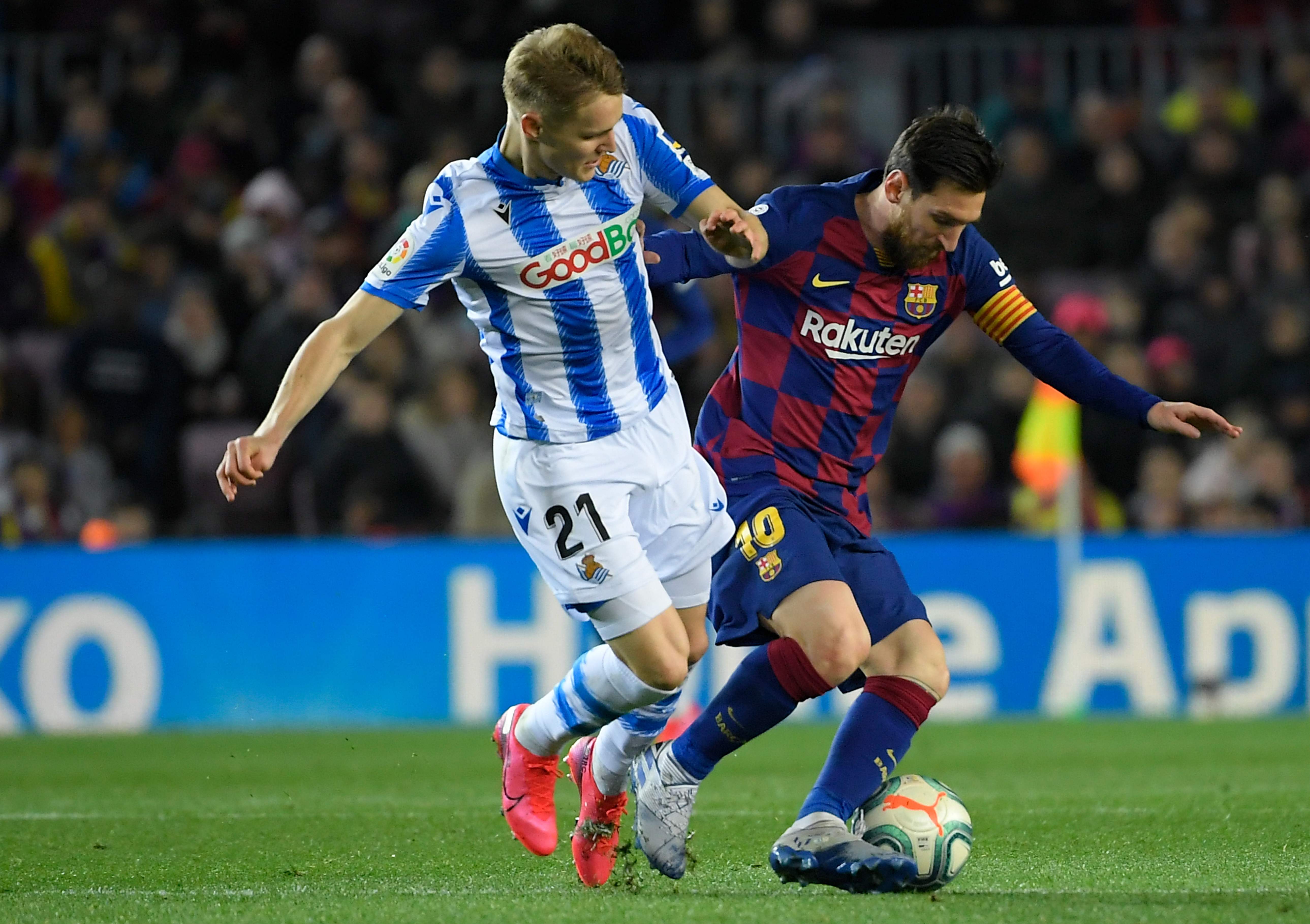 Pemain tengah Real Sociedad Norwegia Martin Odegaard (kiri) menantang pemain depan Argentina Argentina Lionel Messi  