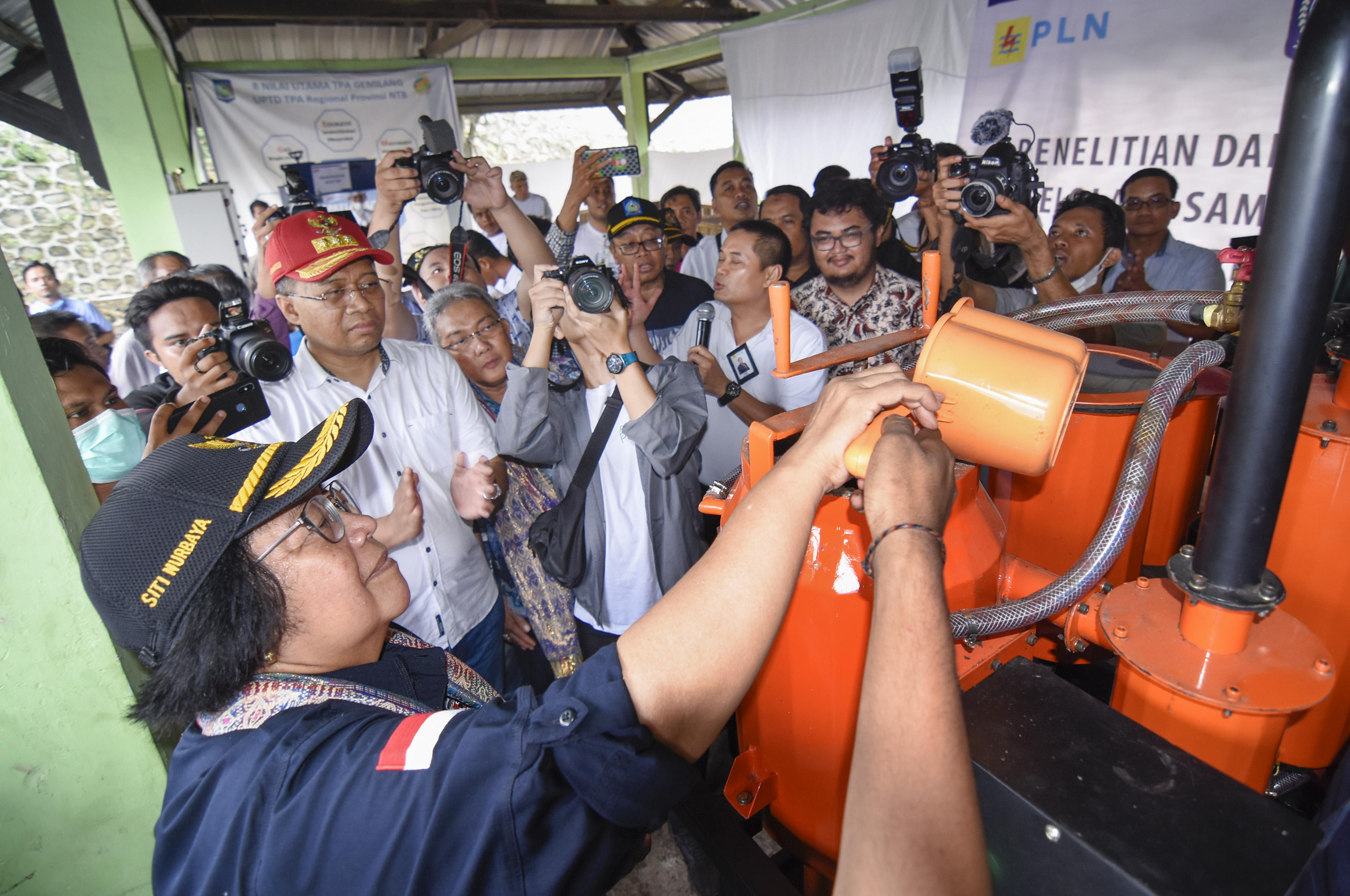 Menteri LHK  Siti Nurbaya (kiri) memasukkan pellet kedalam mesin pengubah pellet menjadi gas disaksikan Gubernur NTB Zulkieflimansyah. 