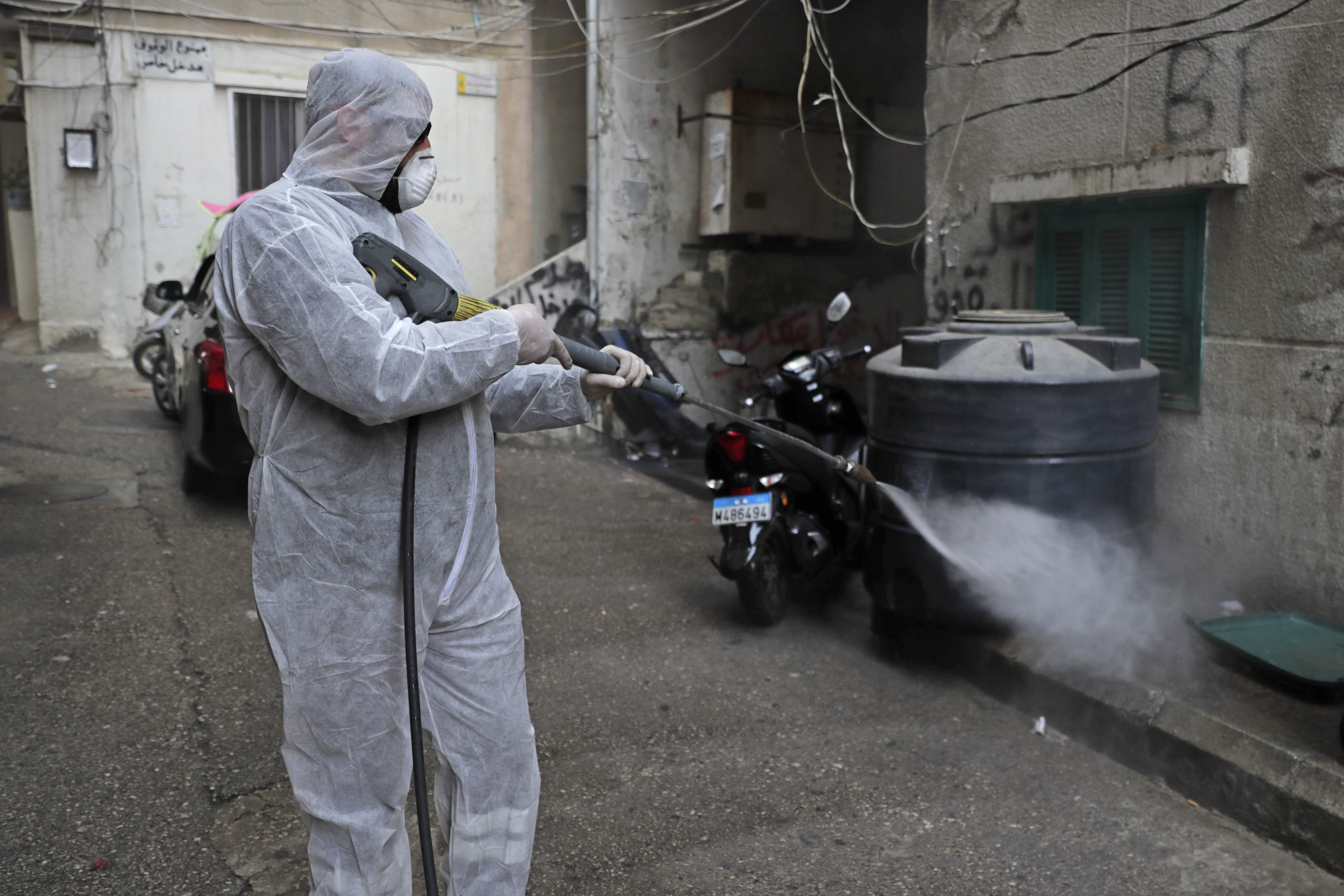 Seorang petugas menyemprotkan cairan disinfektan di sebuah perumahan di Beirut, Libanon.