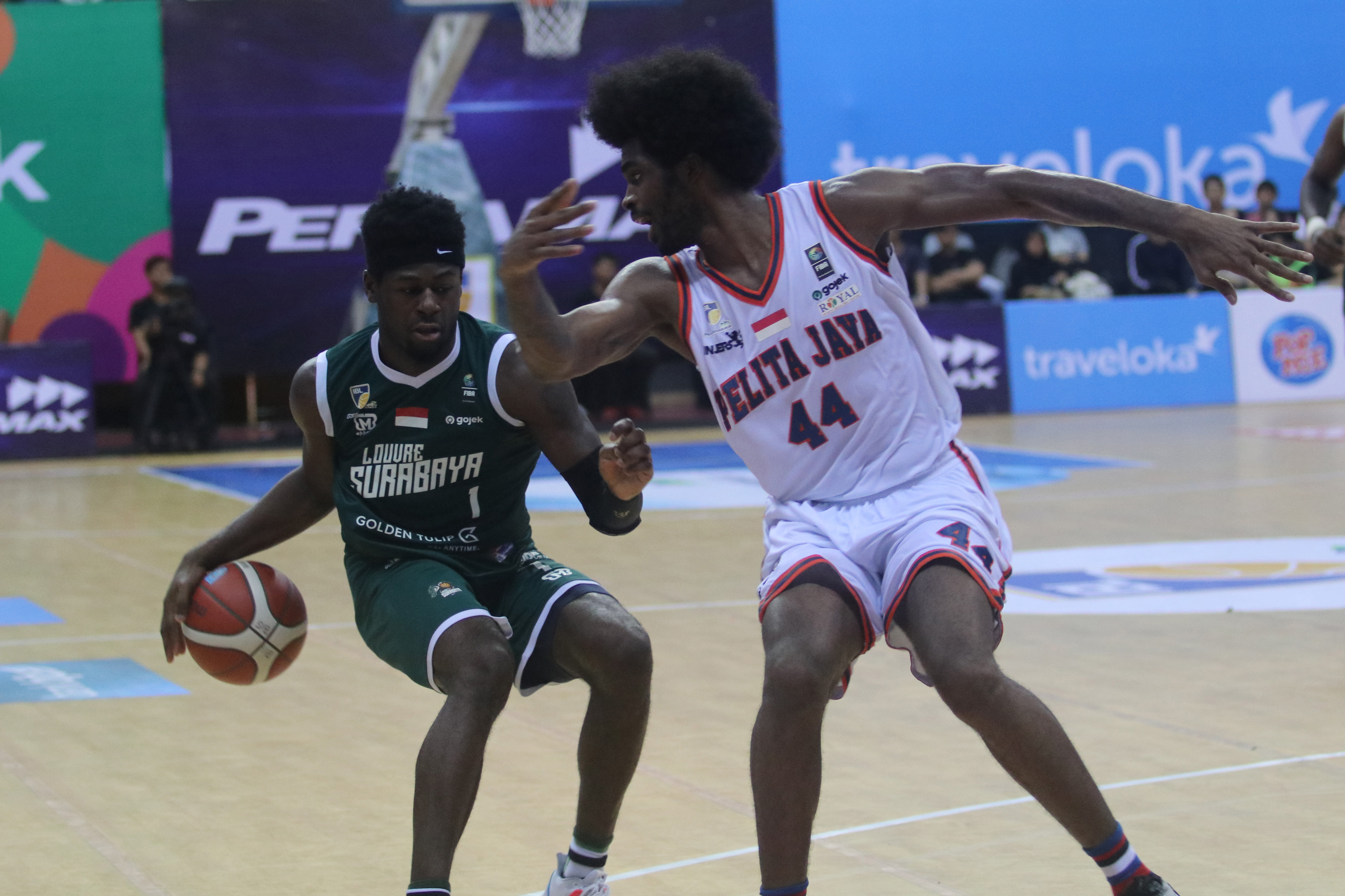 Pebasket Louvre Surabaya Michael Ayodele mencoba menghindari hadangan pemain  Pelita Jaya Bakrie Michael Adam Murray dalam lanjutan IBL 2020