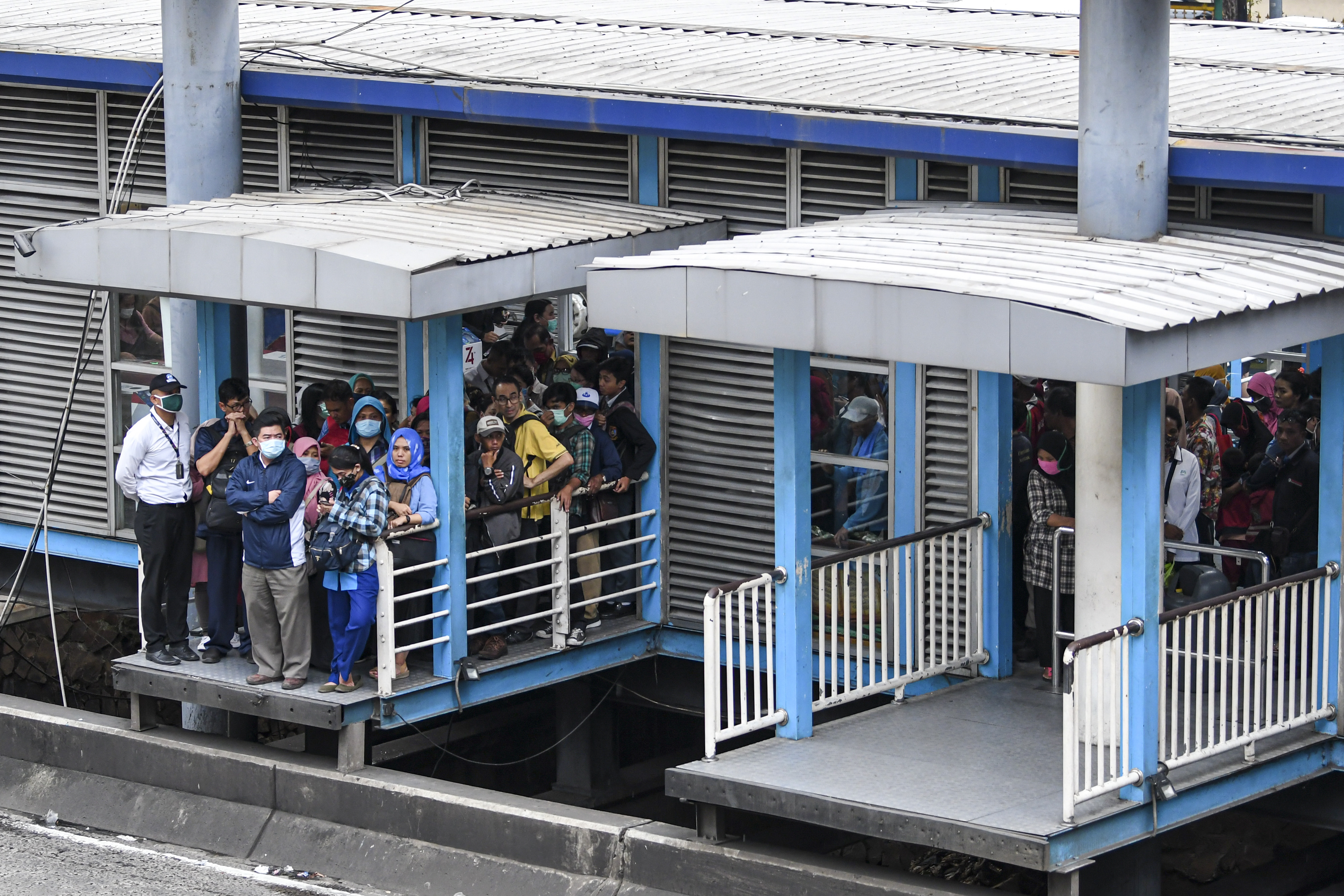  Calon penumpang antre menunggu bus TransJakarta di Halte Harmoni, Jakarta Pusat, Senin (16/3/2020).