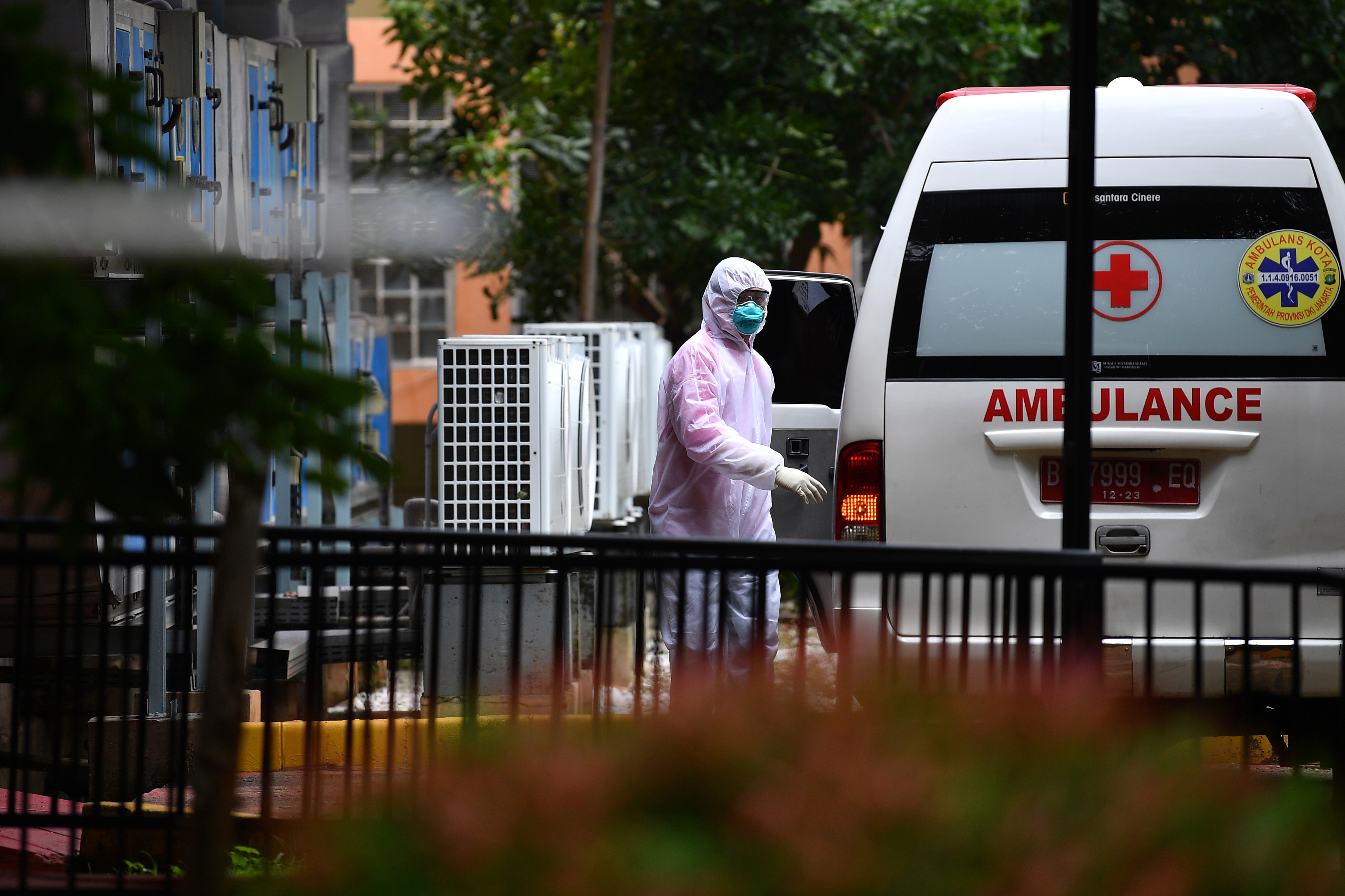 Petugas berjalan ke arah mobil ambulans di samping ruang isolasi RSPI Prof. Dr. Sulianti Saroso, Sunter, Jakarta Utara, Kamis (5/3/2020).
