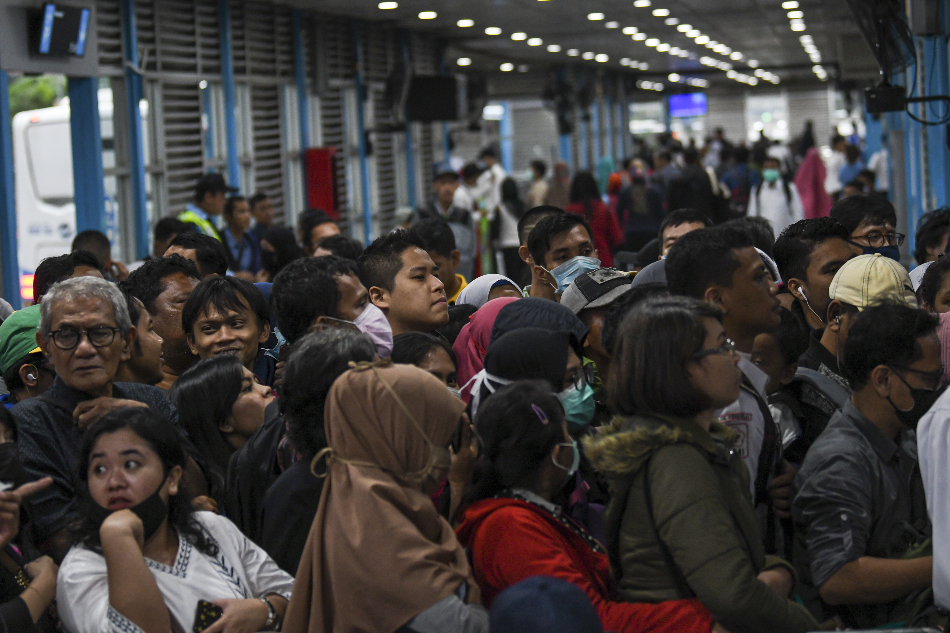 Calon penumpang antre menunggu bus TransJakarta di Halte Harmoni, Jakarta Pusat, Senin (16/3/2020). 