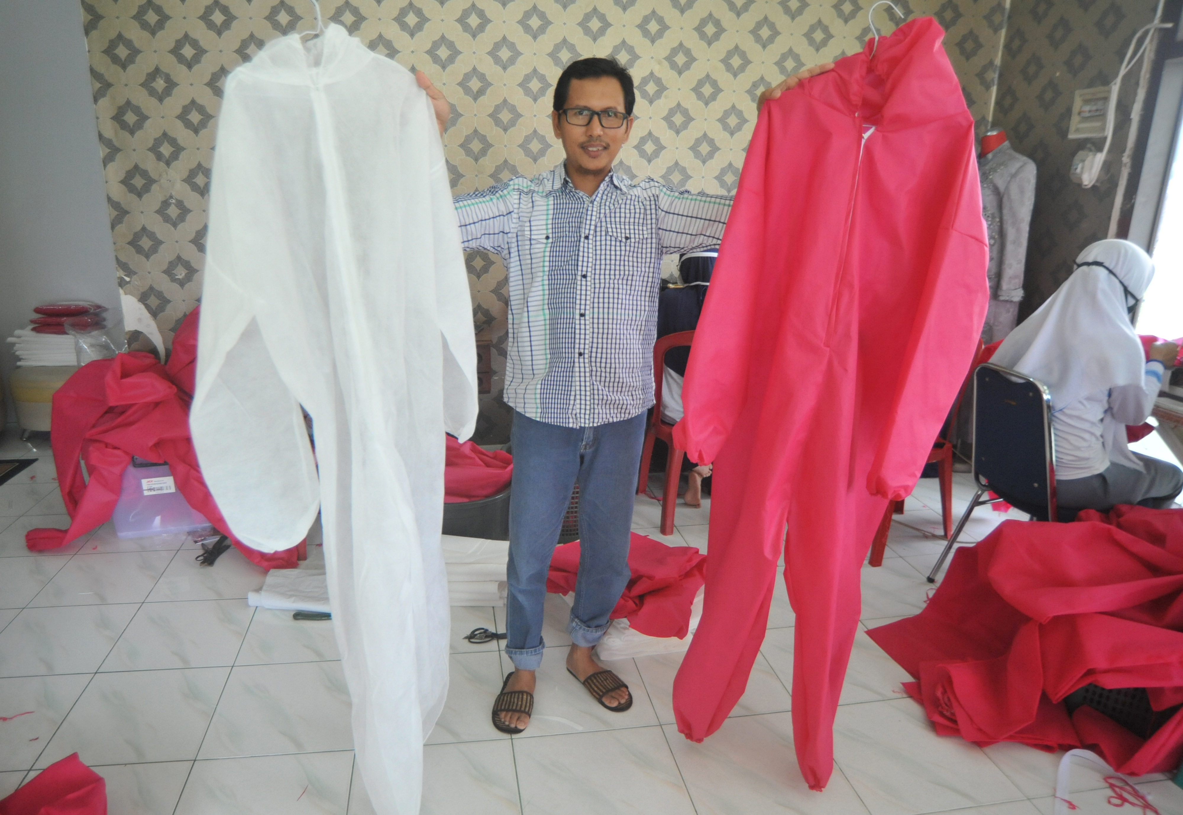 Pemilik UMKM Emi Arlin, Arlin Teguh menunjukan alat pelindung diri (APD) yang dibuat di Padang, Sumatera Barat, Kamis (26/3). 