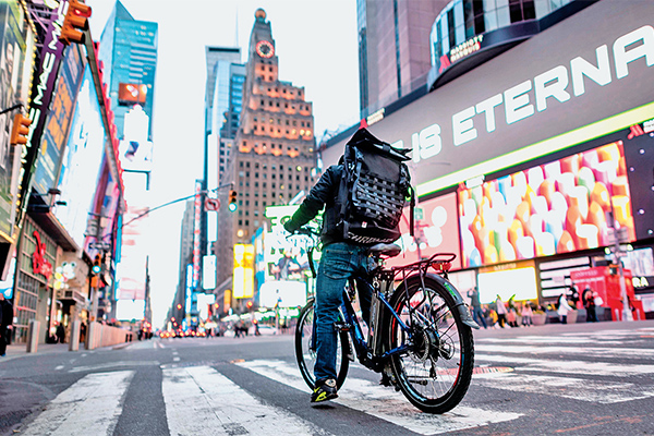Seorang pengantar makanan melintas di Times Square Manhattan, di New York City,
