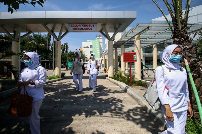 Pekerja rumah sakit menggunakan masker di RSPI Sulianti Saroso, Jakarta.