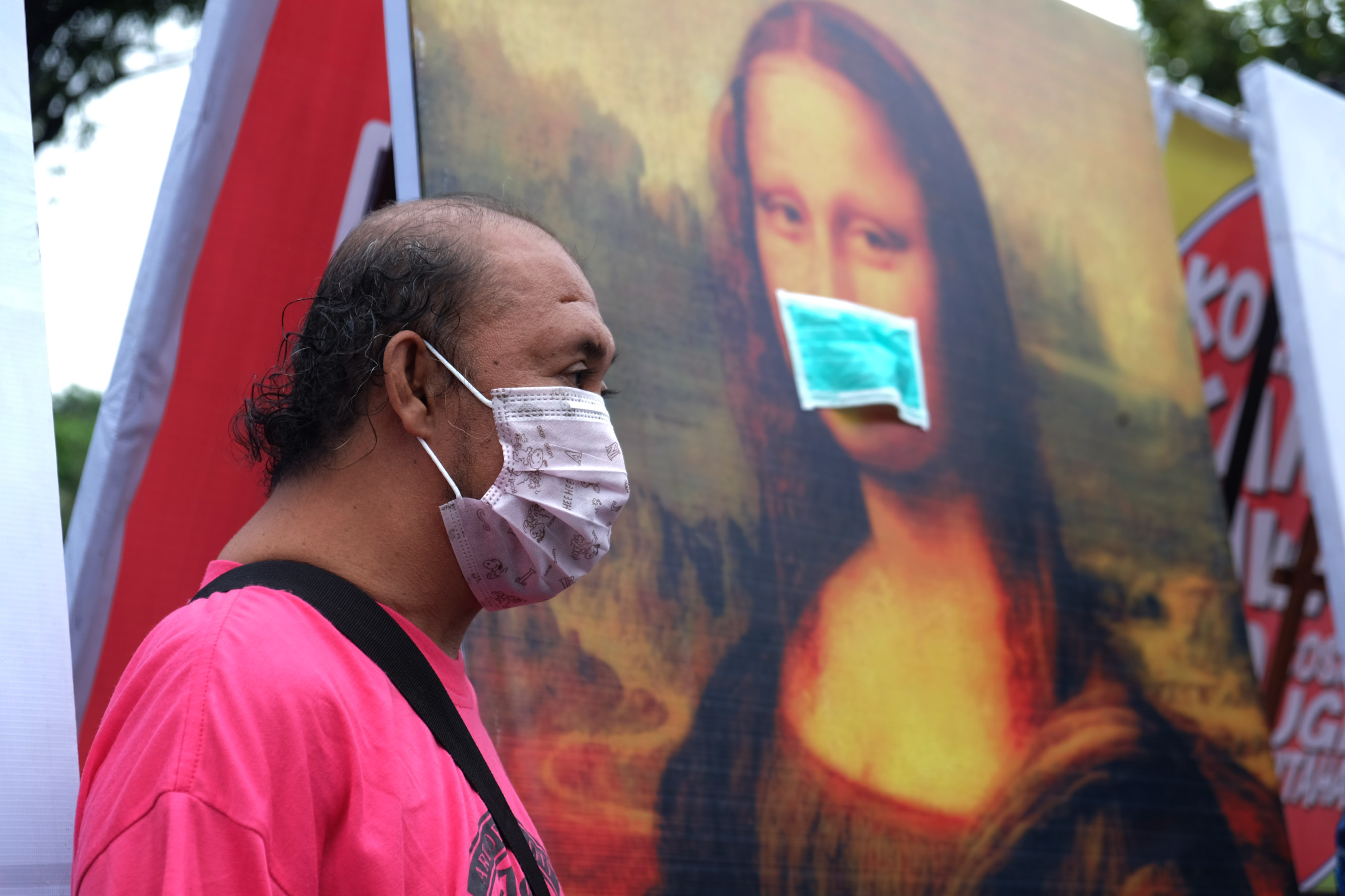 Pengunjung memakai masker saat mengamati karya lukis dan karikatur pada pameran bertajuk Masker di Solo, Jawa Tengah, Minggu (8/3/2020).
