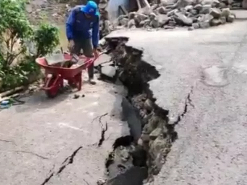 Petugas PPSU Kecamatan Matraman, Jakarta Timur, mendorong troli berisi material kawat beronjong di lokasi terparah jalan amblas.