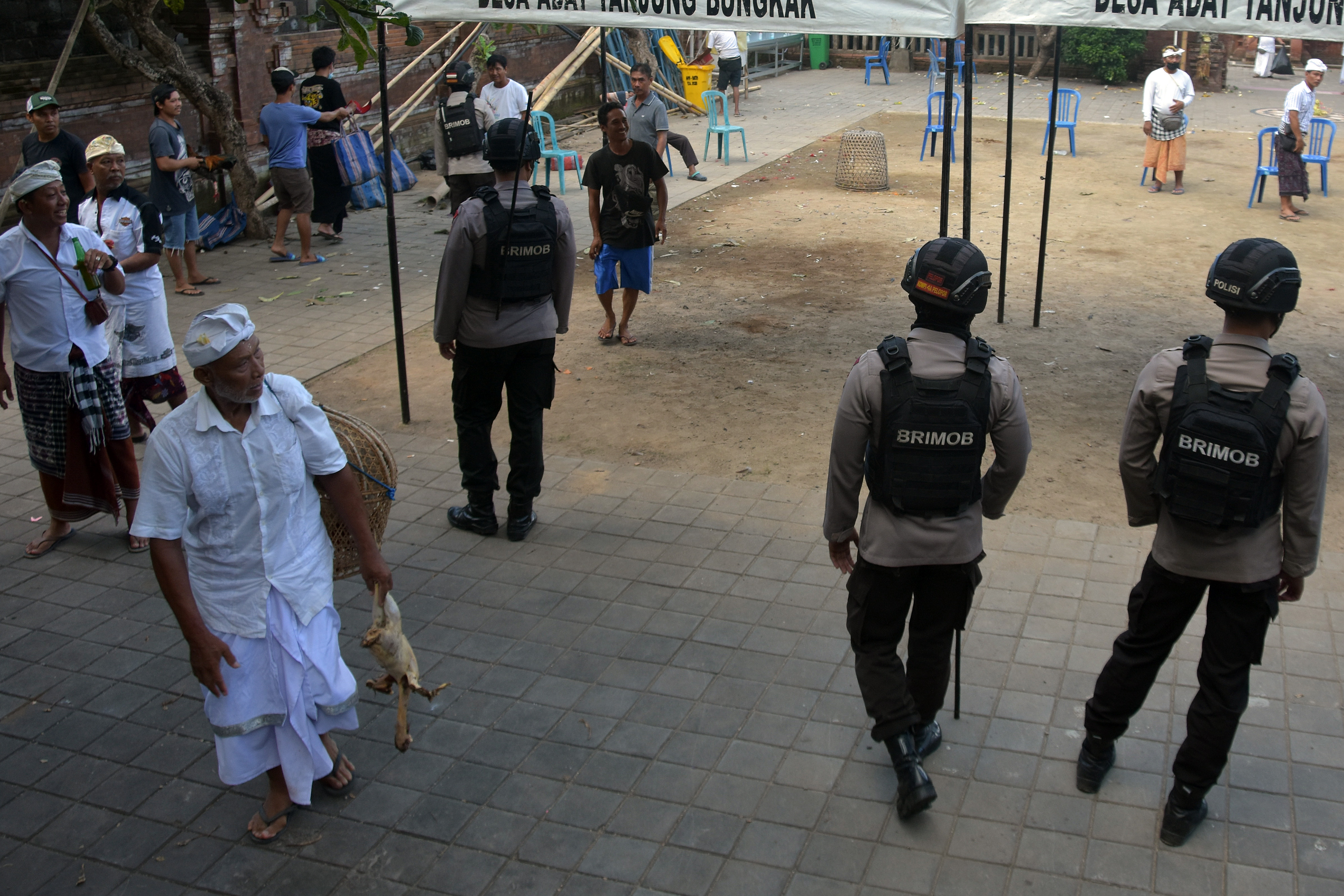 Anggota Brimob Polda Bali membubarkan warga yang berkerumun ssat sabung ayam