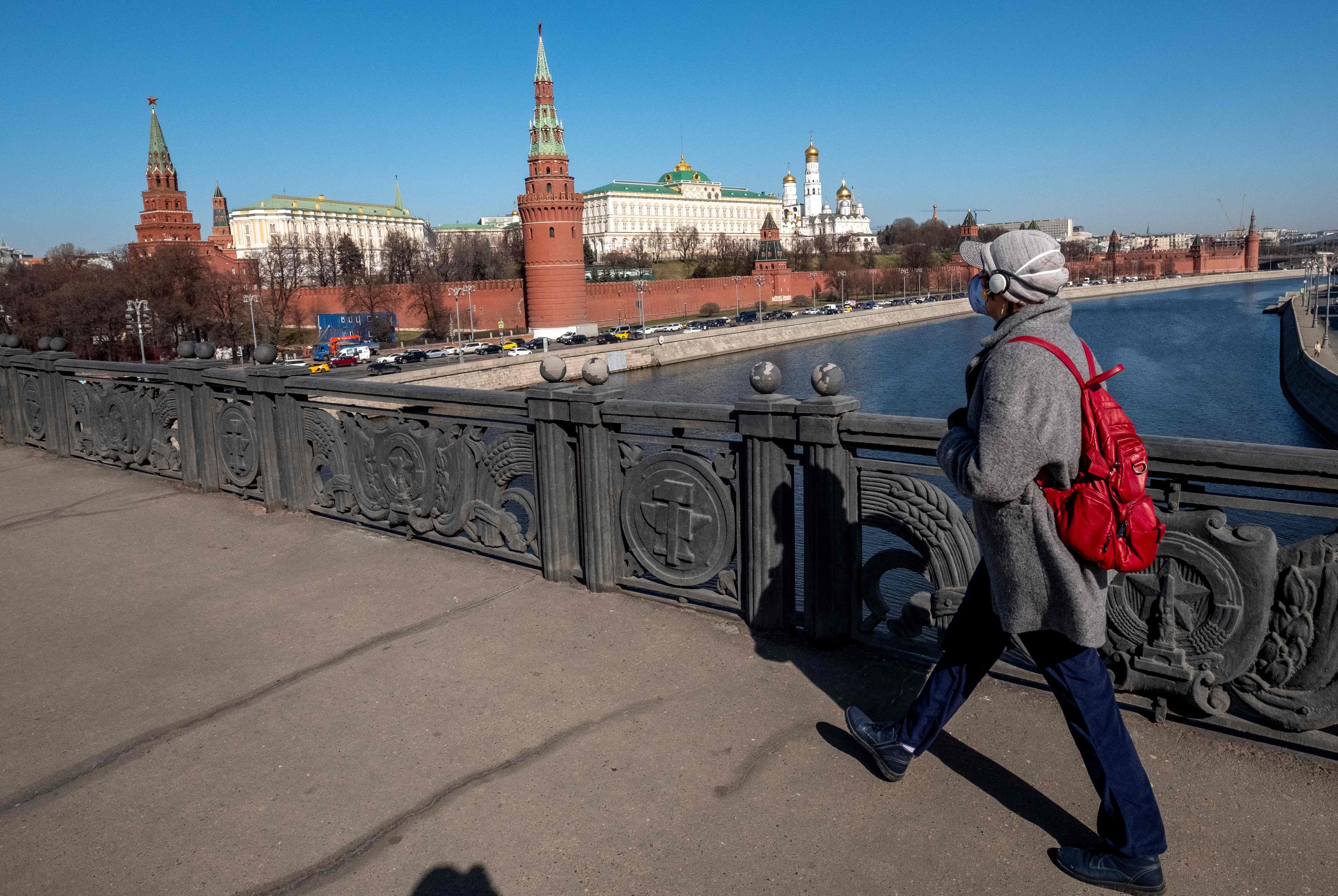 Seorang warga tengah berjalan dengan menggunakan masker di tengah wabah covid-19 yang juga melanda Rusia.