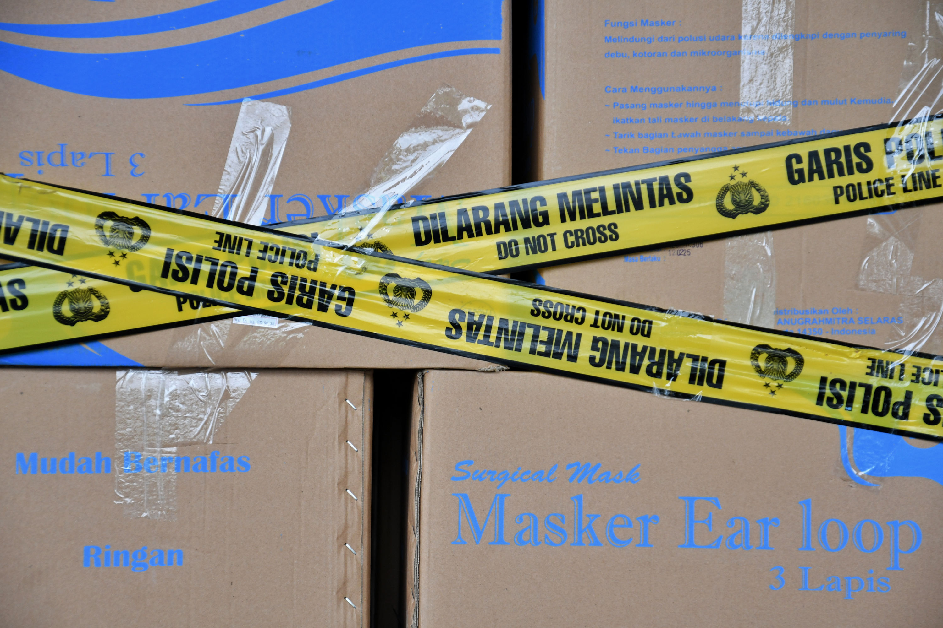 Garis polisi di sejumlah kotak berisi masker.