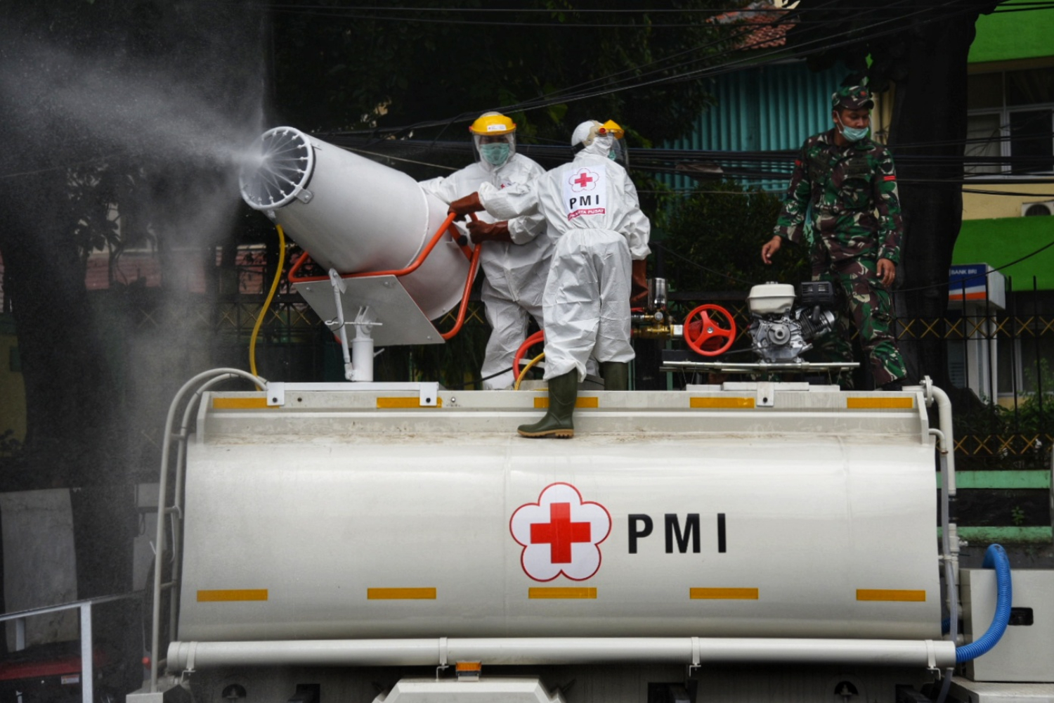 Petugas Palang Merah Indonesia (PMI) Jakarta Pusat menyemprotkan cairan disinfektan menggunakan truk blower di Jakarta Pusat.