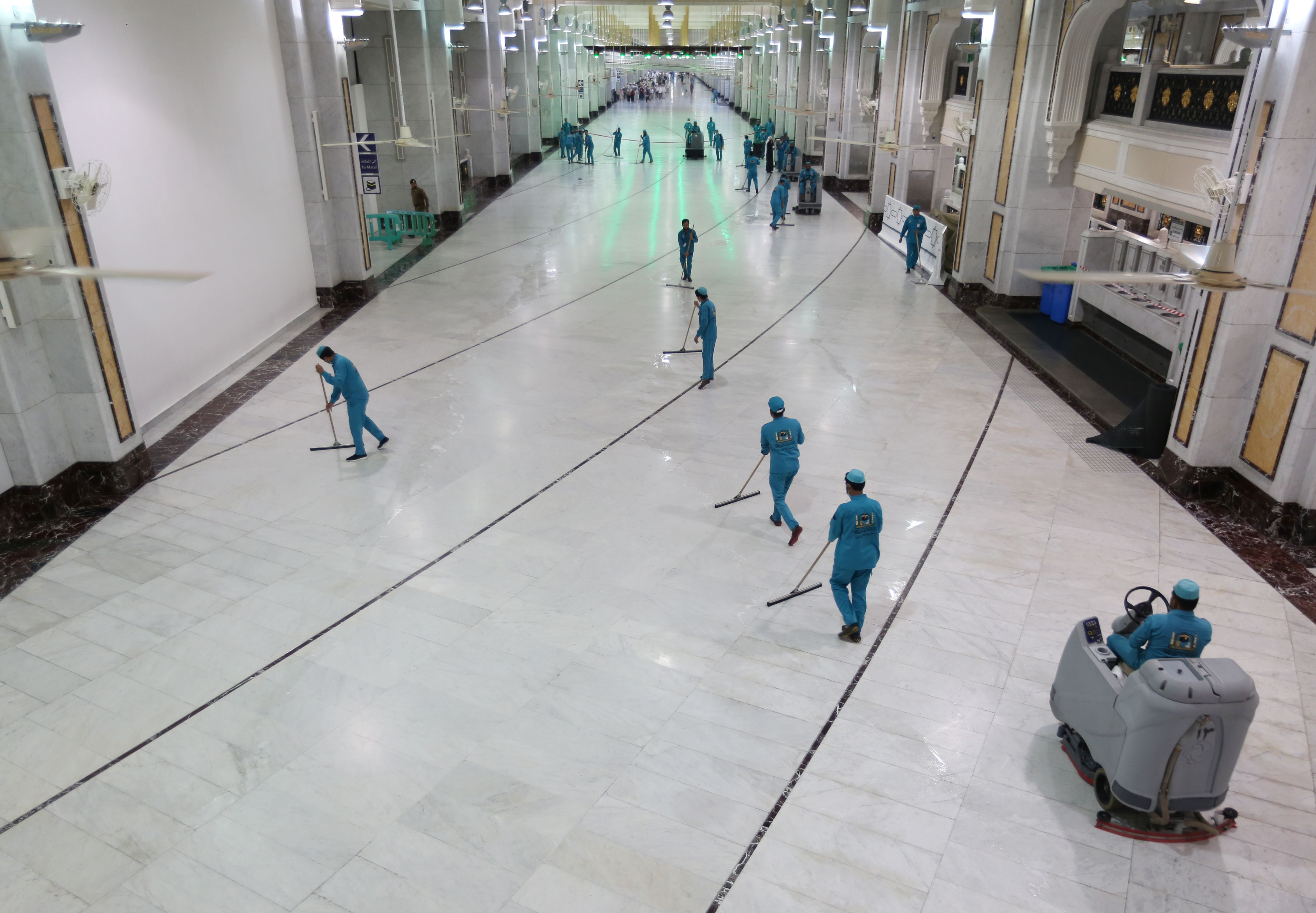 Petugas membersihkan masjidil Haram pascapenutupan sementara umrah di Arab Saudi