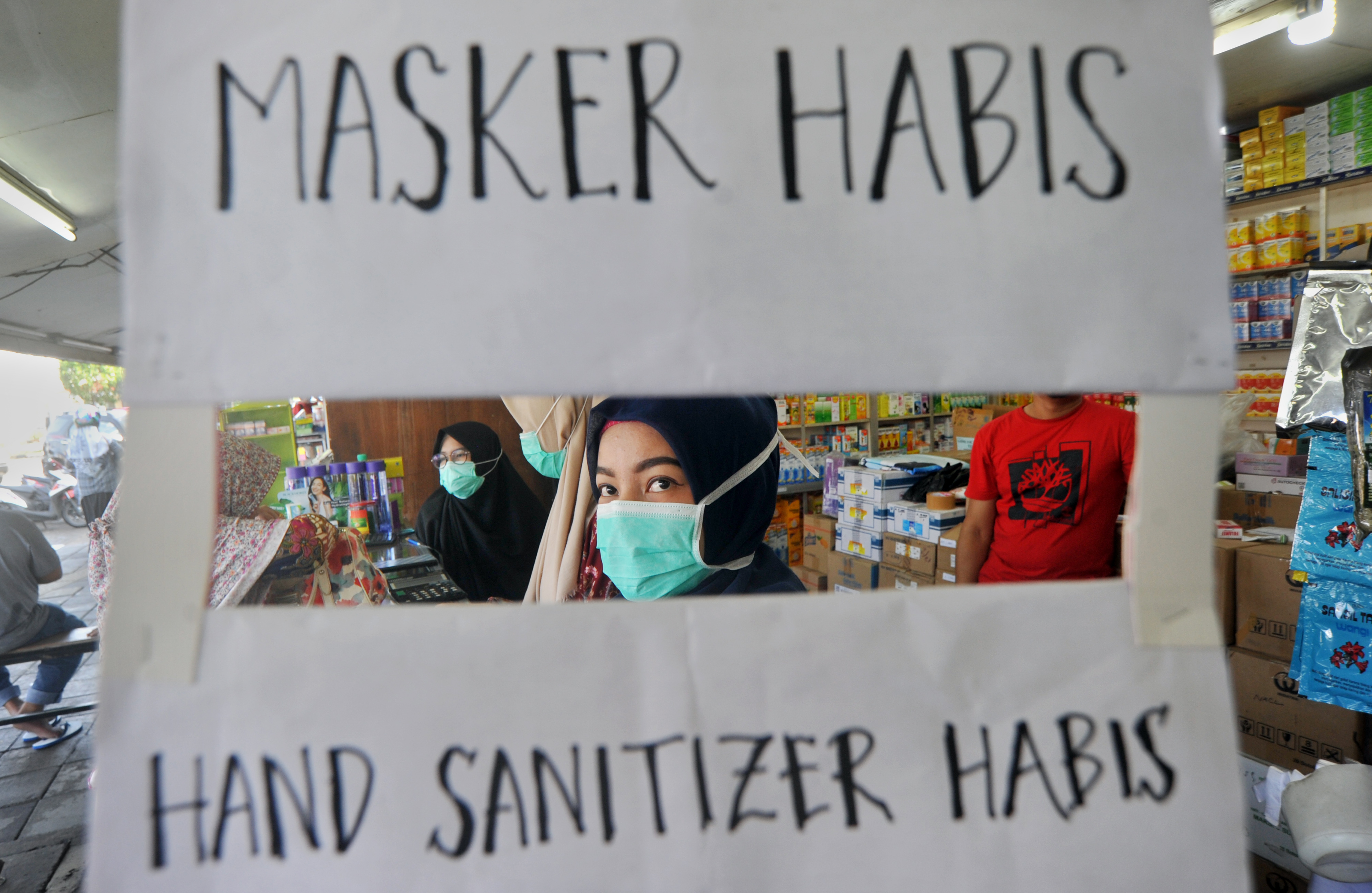 Petugas apotek memasang tanda stok masker habis
