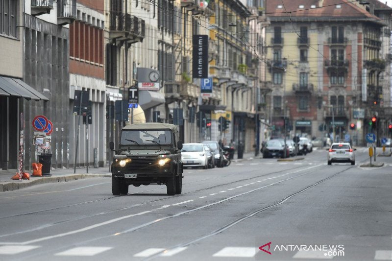 Sebuah kendaraan militer Italia berpatroli selama lockdown mencegah penyebaran virus corona di Milan pada 22 Maret 2020. 
