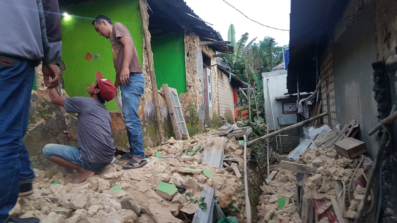 Warga Desa Purwabakti, Pamijahan, Kabupaten Bogor memperbaiki tembok rumahnya yang ambruk akibat gempa Sukabumi, Selasa (10/3/2020)
