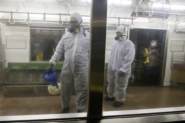 Petugas menyemprotkan disinfektan di gerbong KRL untuk mencegah penyebaran virus korona.  