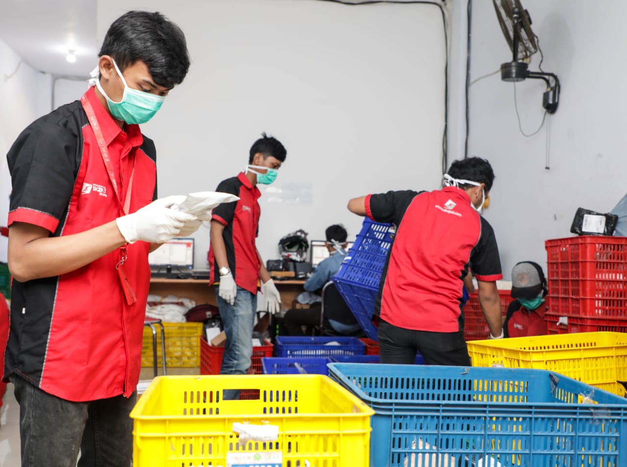 Petugas tengah menyortir kriman menggunakan masker dan sarung tangan.