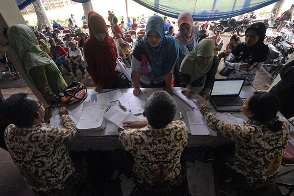 Sejumlah warga mengantre pembagian dana santunan kematian sebesar Rp 2 juta di Kantor Dinas Tenaga Kerja dan Sosial (Disnakersos) Kota Depok