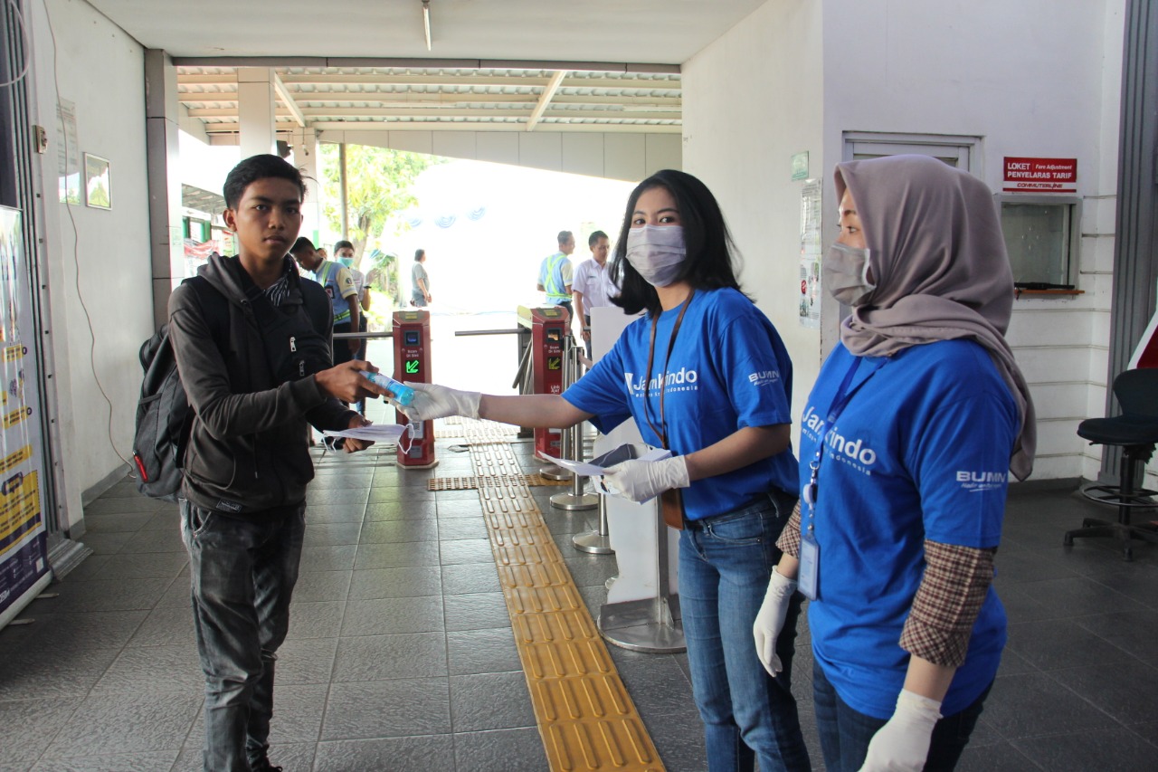 Karyawan Jamkrindo membagikan masker bagi komuter pengguna KRL. 