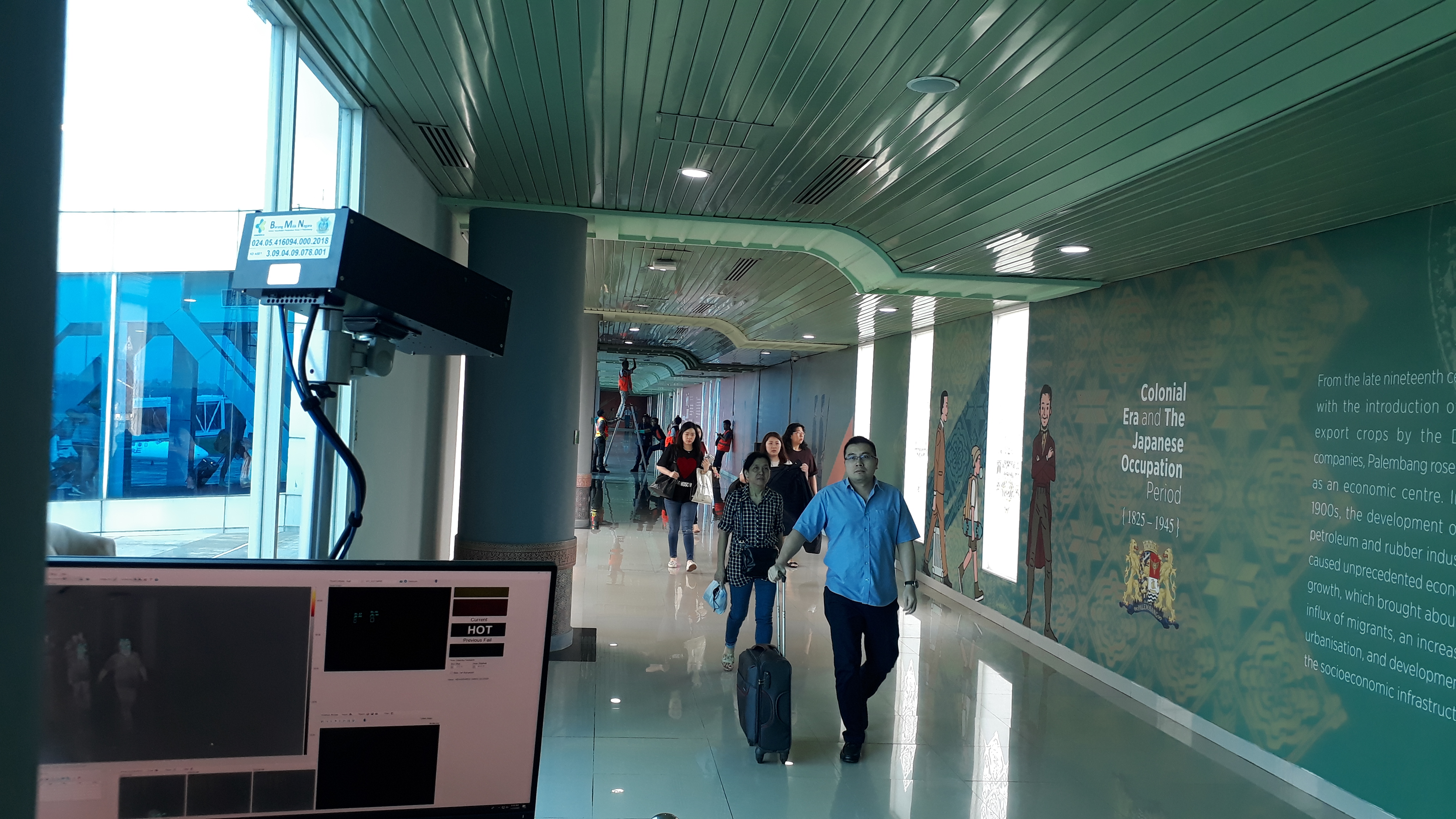 KKP Palembang melakukan pemindaian suhu tubuh penumpang yang datang dari Singapura menggunakan alat thermal scanner di Bandara SMB II.