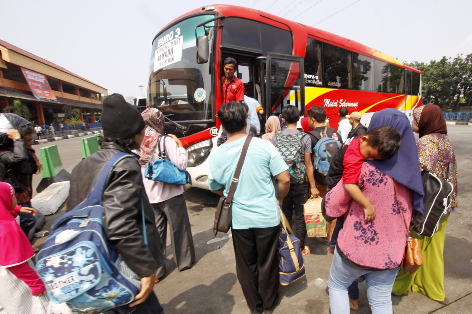 Pemudik bergegas masuk ke dalam bus antar kota antar provinsi (AKAP) di Terminal Kampung Rambutan, Jakarta.
