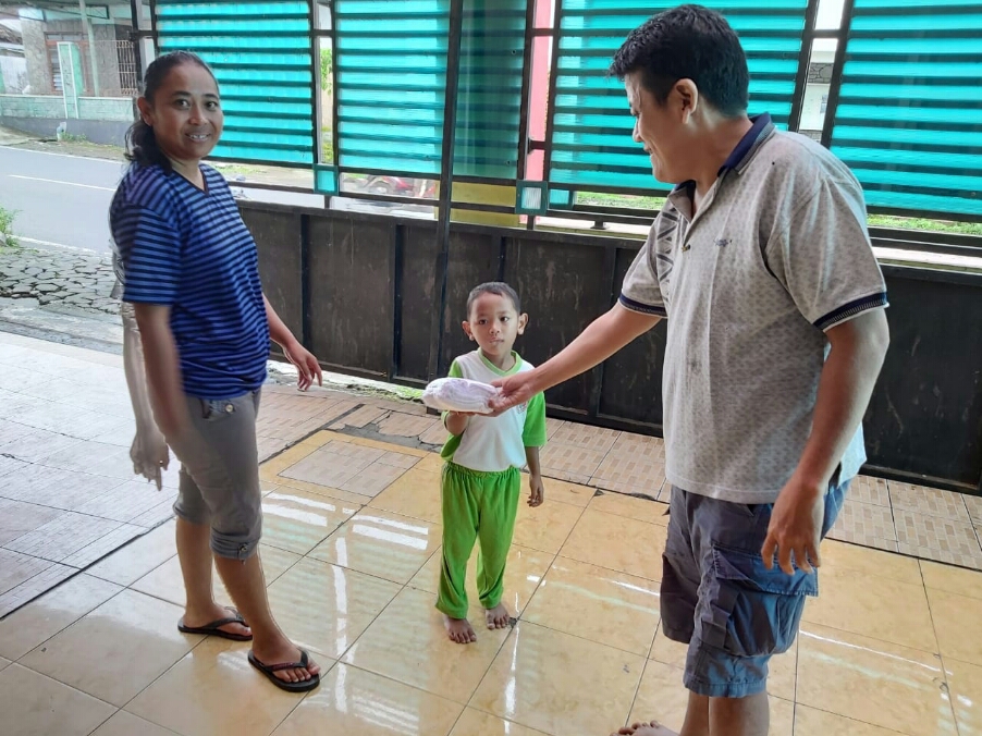 Kristiaji Tjandra (kanan) membagikan masker kepada warga di rumahnya di Salatiga.