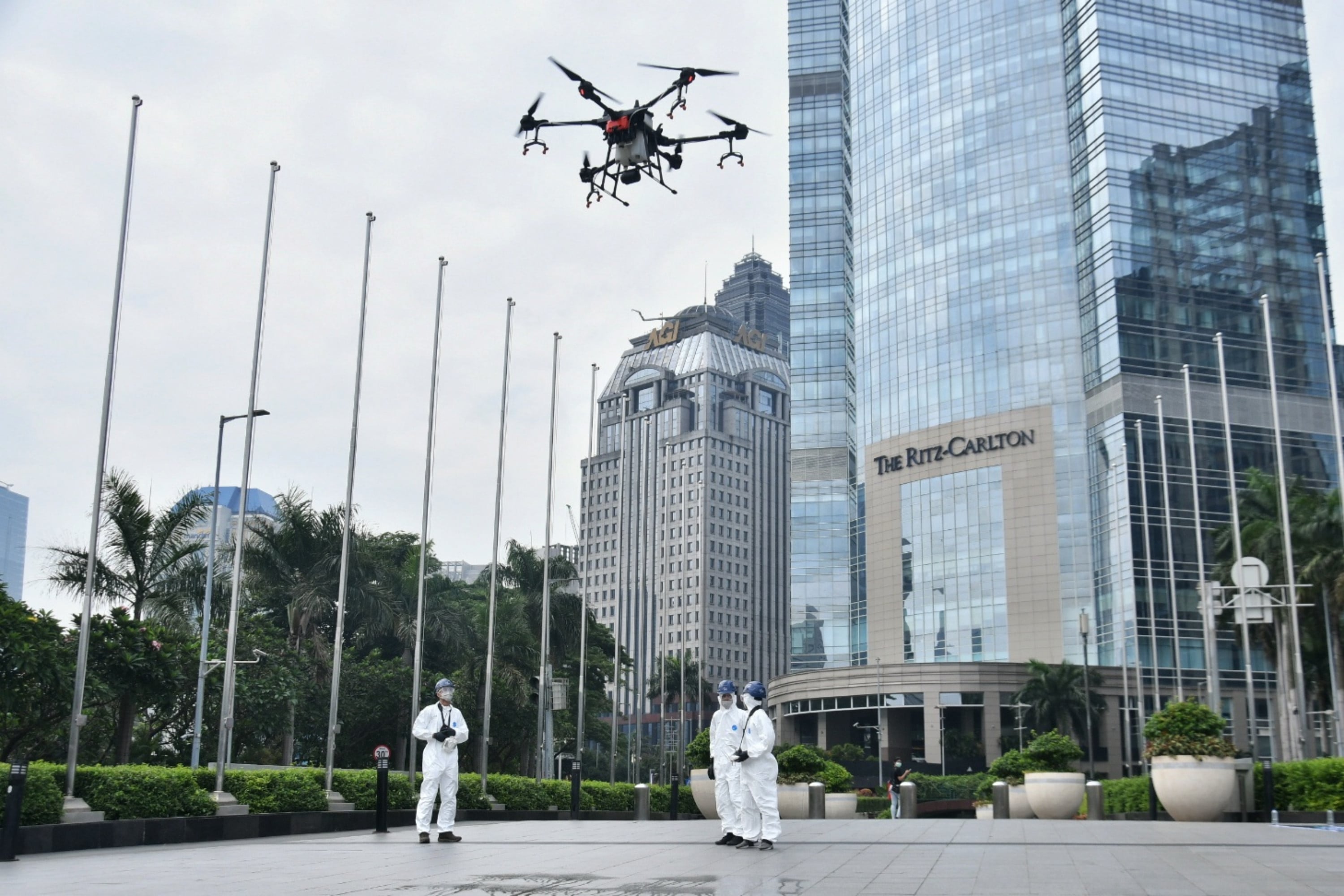 Petugas mengendalikan drone berisi cairan disinfektan di kawasan Jalan Jenderal Sudirman, Jakarta.