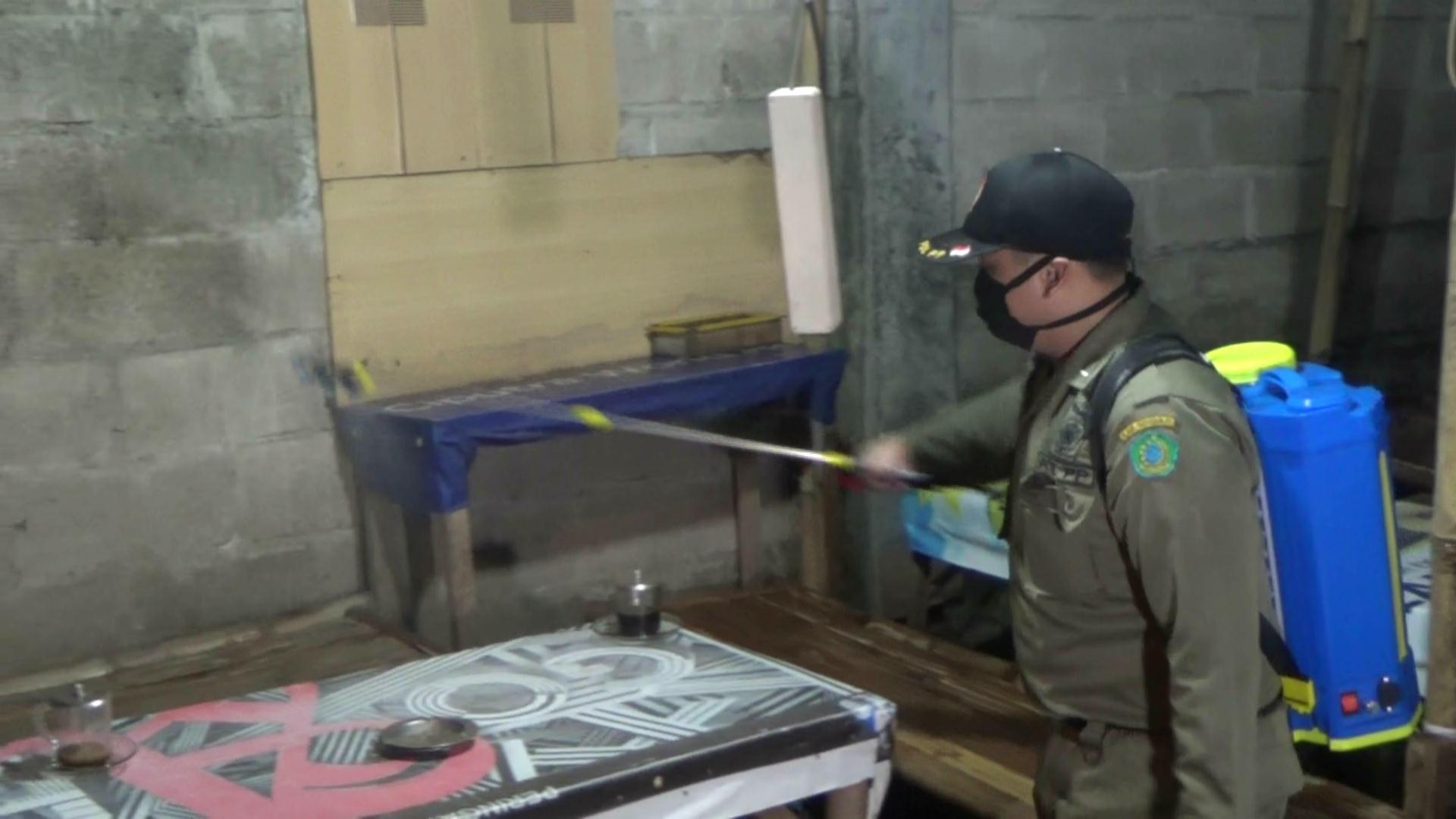 Aparat menyemprotkan disinfektan di warumg di Sidoarjo