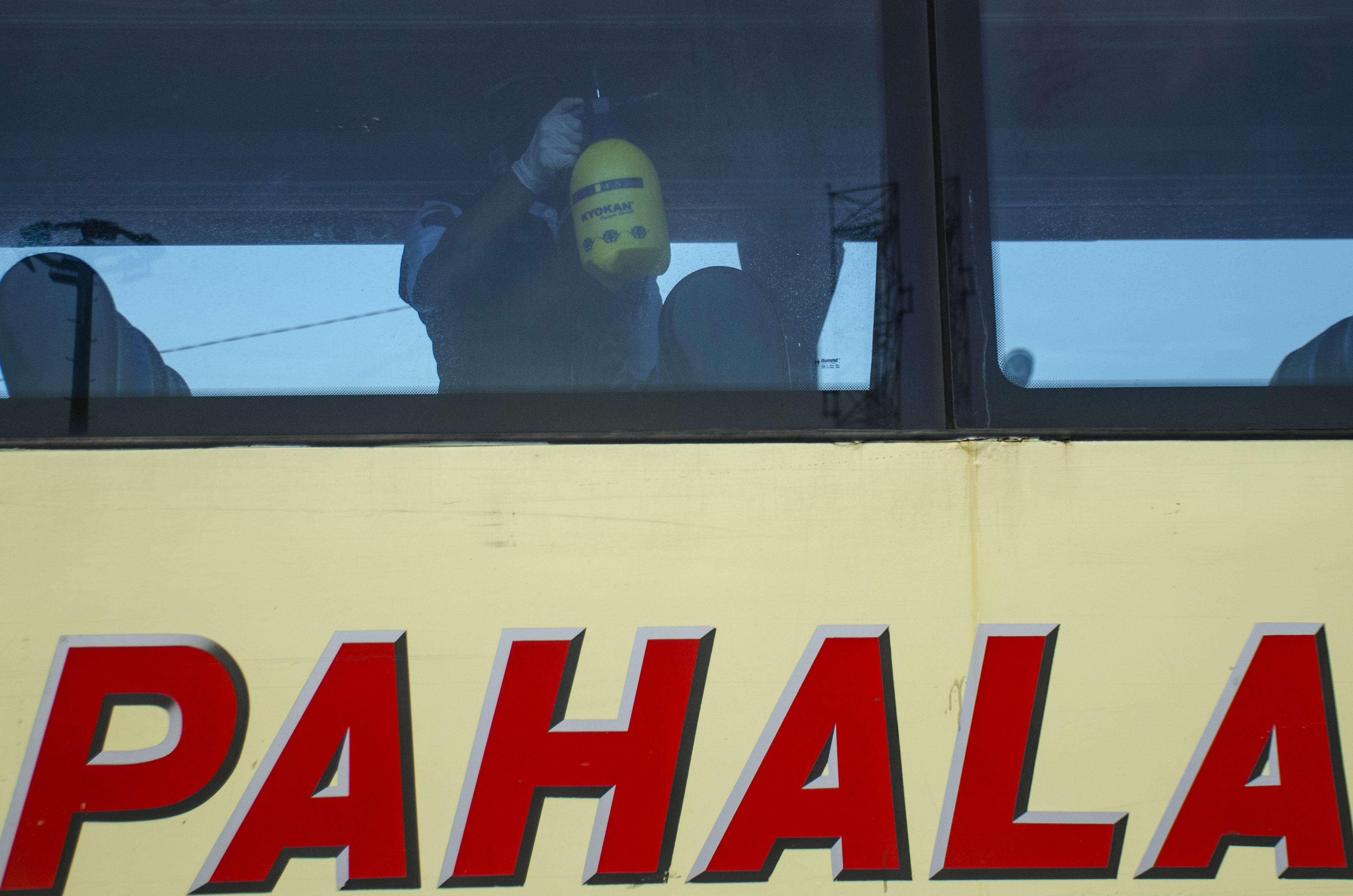  Petugas menyemprotkan cairan disinfektan pada bus.