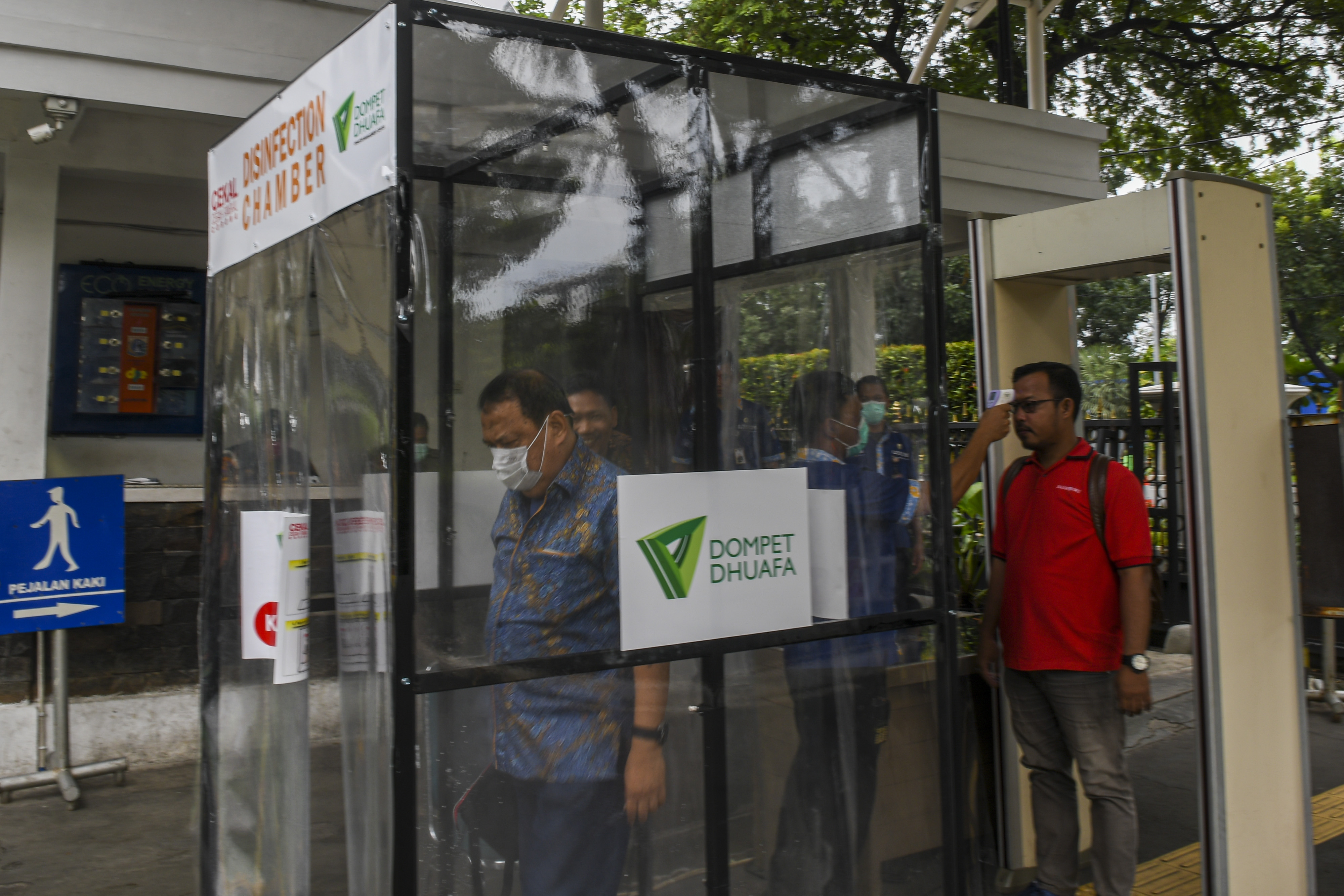 Pegawai berada di dalam bilik disinfektan di Balai Kota, Jakarta.
