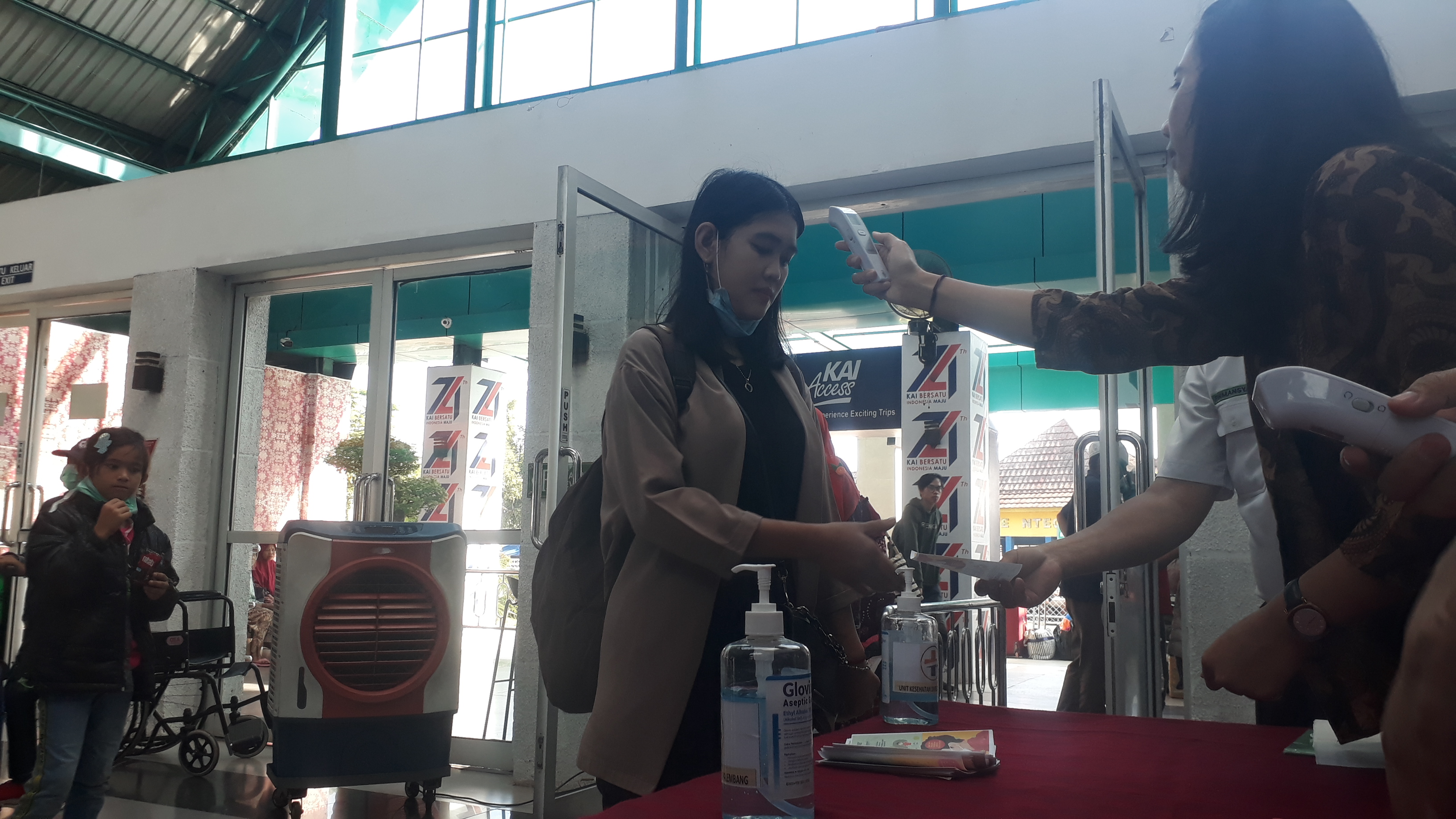 Petugas mengecek suhu tubuh penumpang di pintu keberangkatan Stasiun Kertapati, Palembang, Sumsel, Jumat (6/3/2020). 